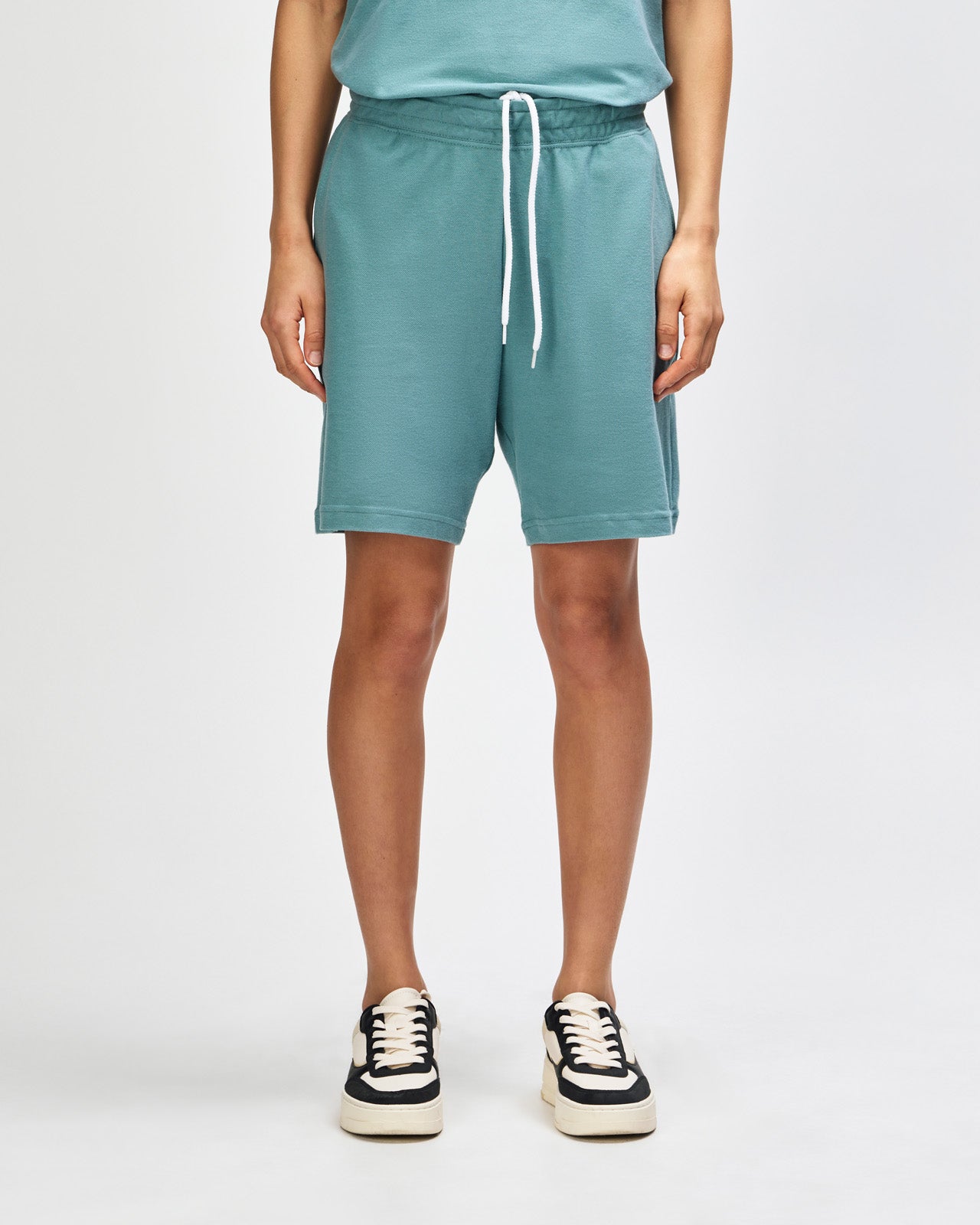 Model wearing a Pique Unisex Gym Shorts (front pose) -arctic