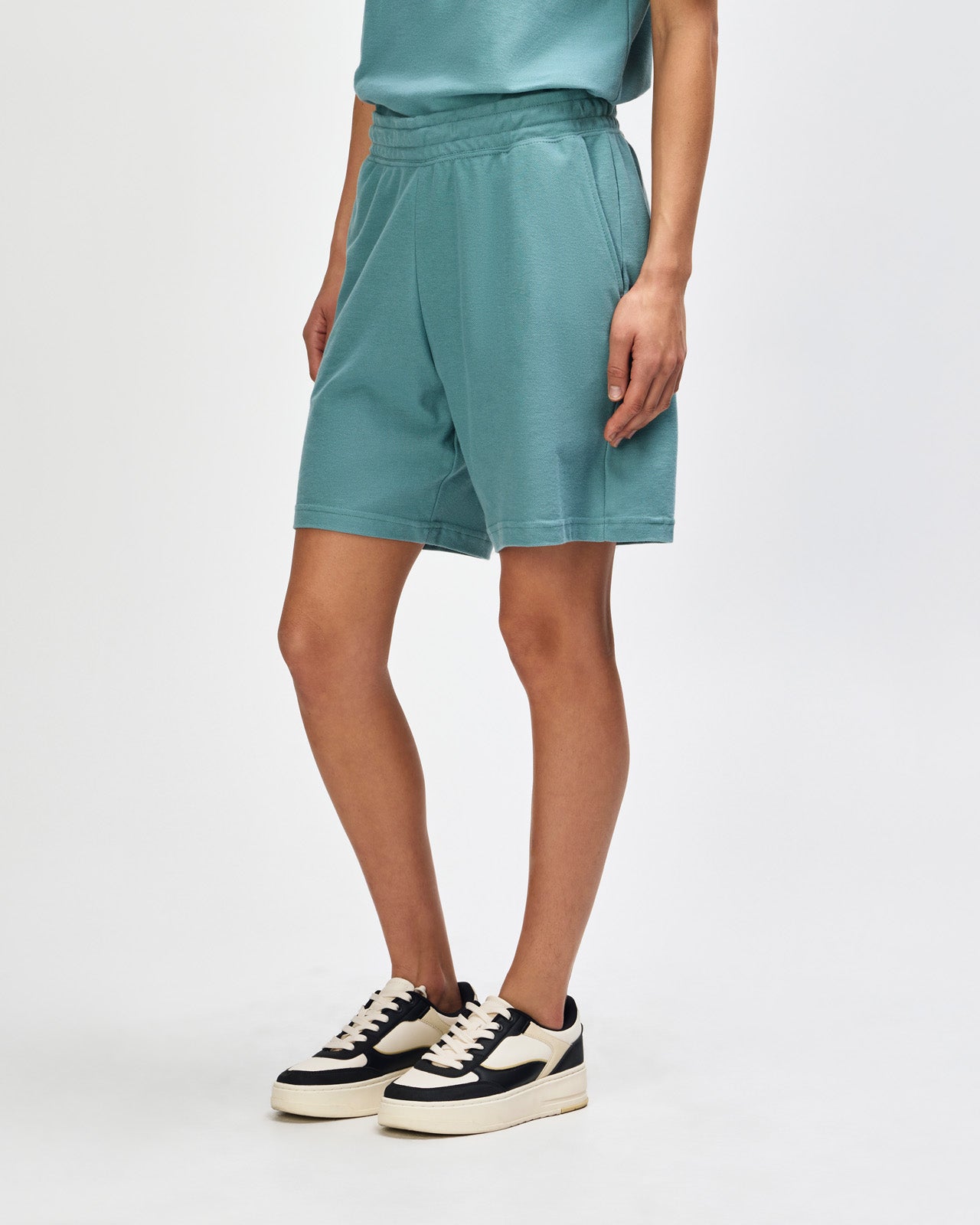 Model wearing a Pique Unisex Gym Shorts (front pose) -arctic