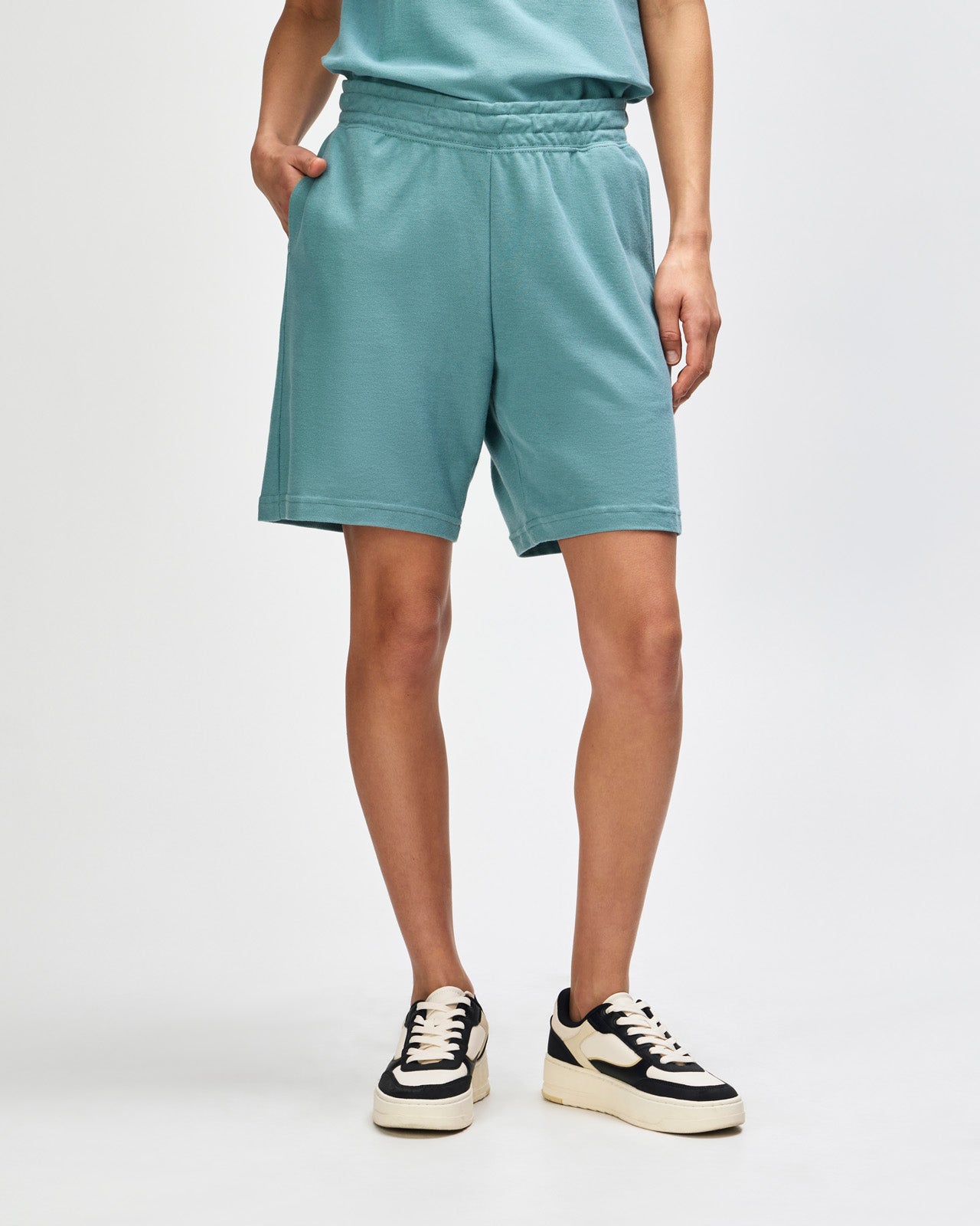 Model wearing a Pique Unisex Gym Shorts (front pose) -arctic