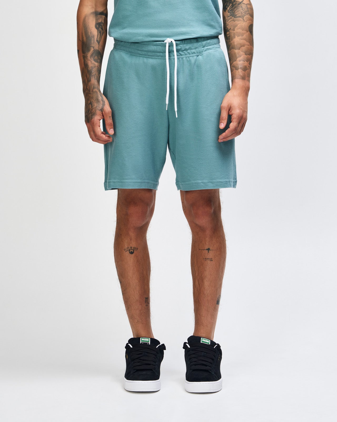 Model wearing a Pique Unisex Gym Shorts (front pose) -arctic