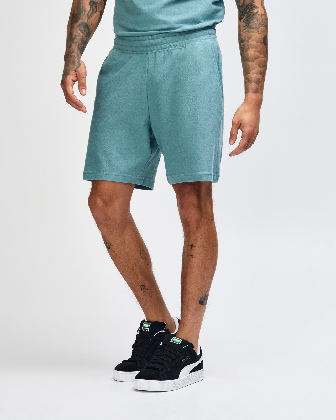 Model wearing a Pique Unisex Gym Shorts (front pose) -arctic