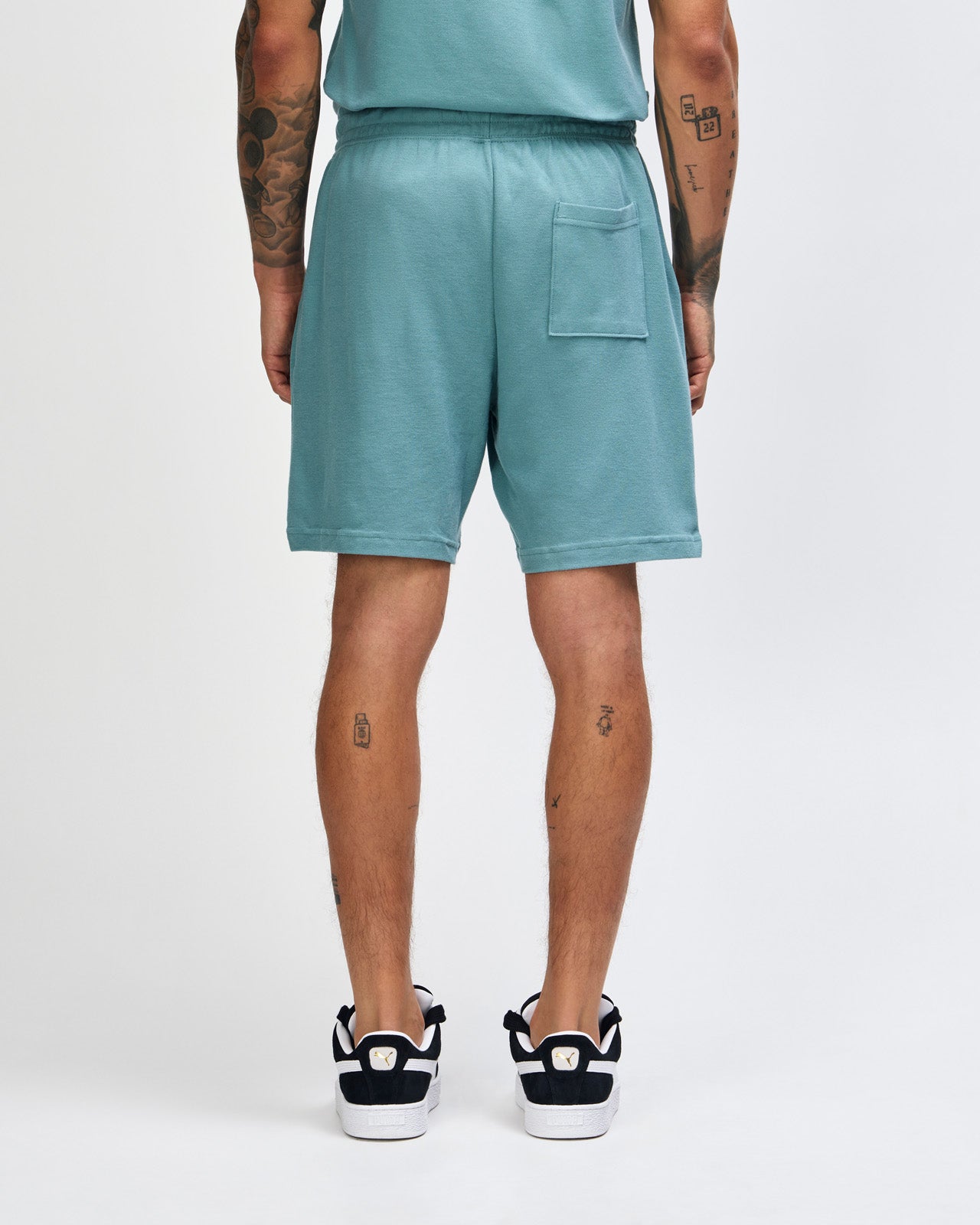 Model wearing a Pique Unisex Gym Shorts (front pose) -arctic