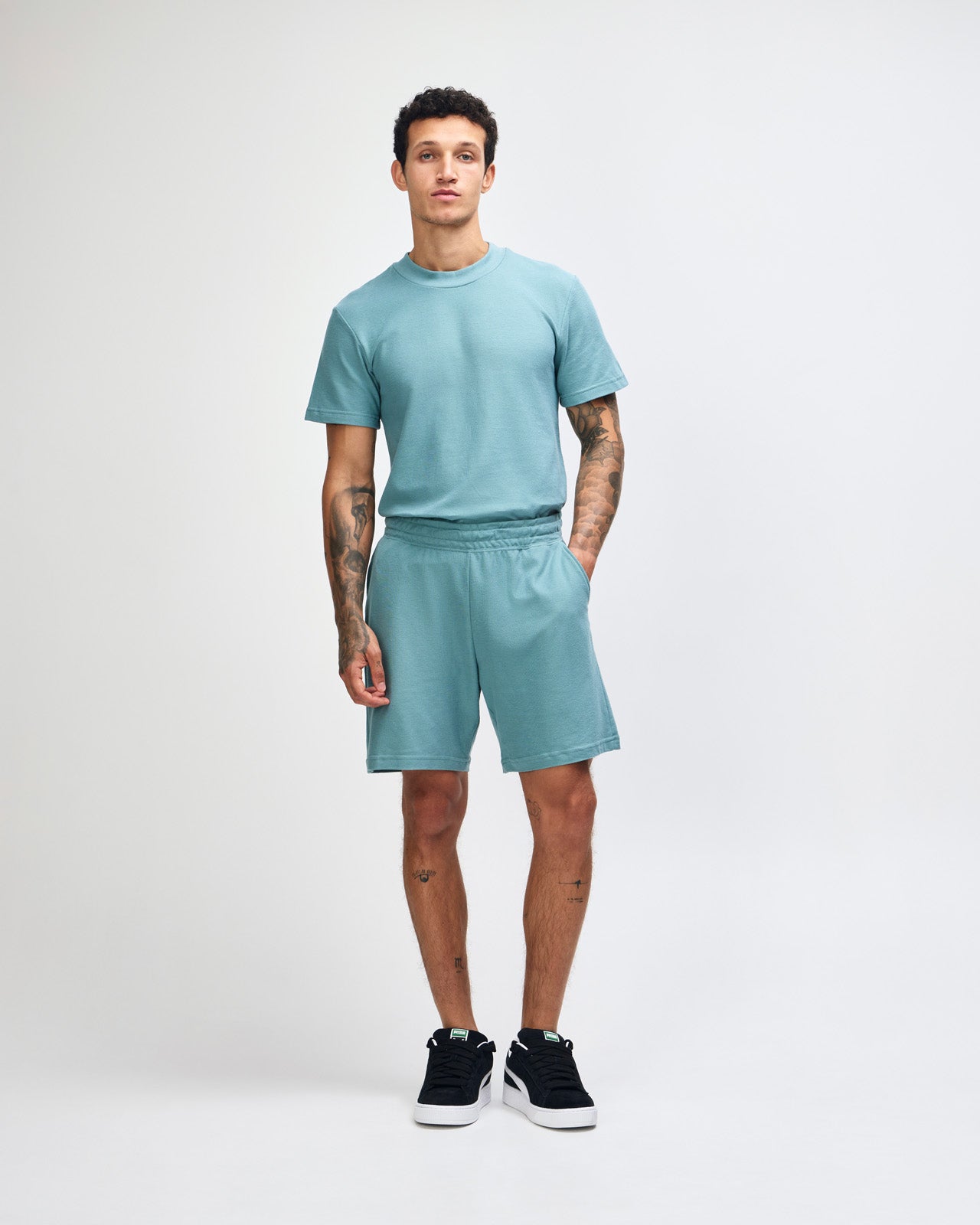 Model wearing a Pique Unisex Gym Shorts (front pose) -arctic