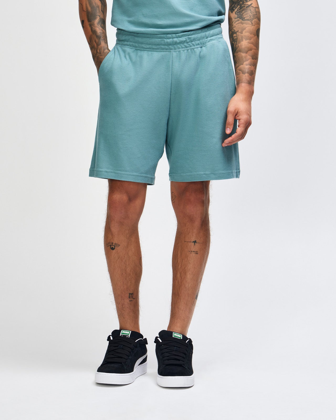 Model wearing a Pique Unisex Gym Shorts (front pose) -arctic