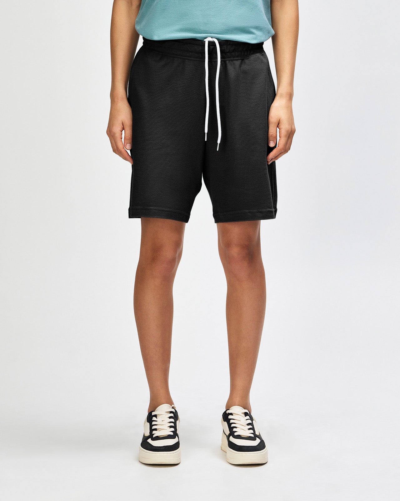 Model wearing a Pique Unisex Gym Shorts (front pose) -black