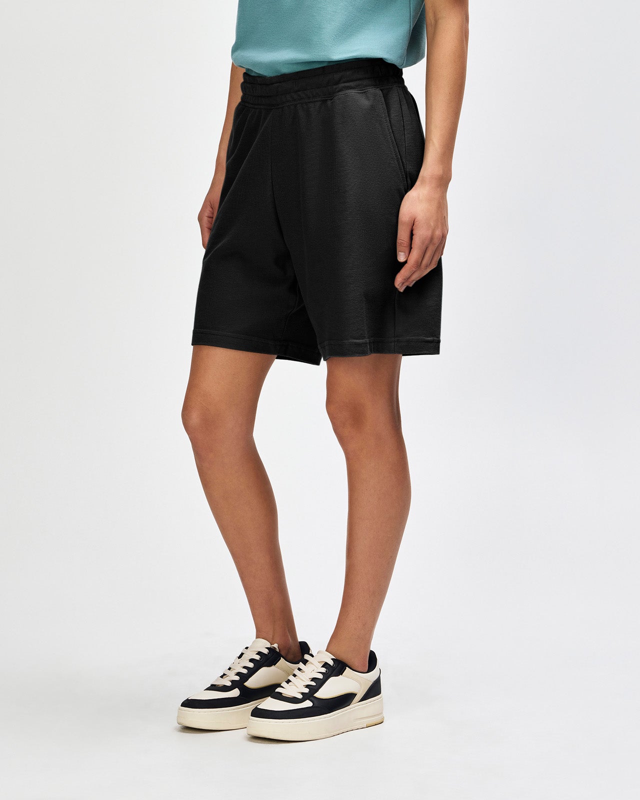 Model wearing a Pique Unisex Gym Shorts (front pose) -black