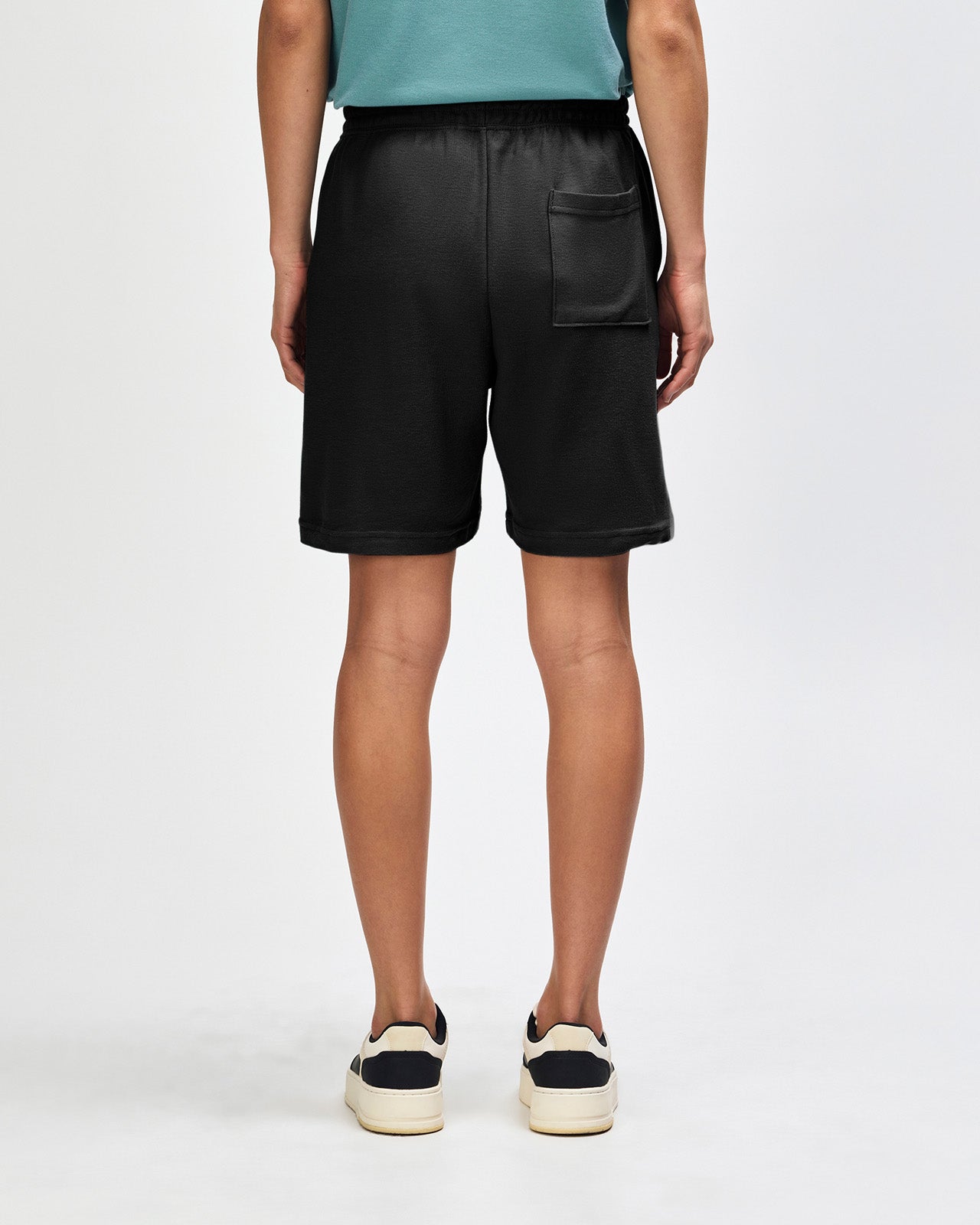 Model wearing a Pique Unisex Gym Shorts (front pose) -black