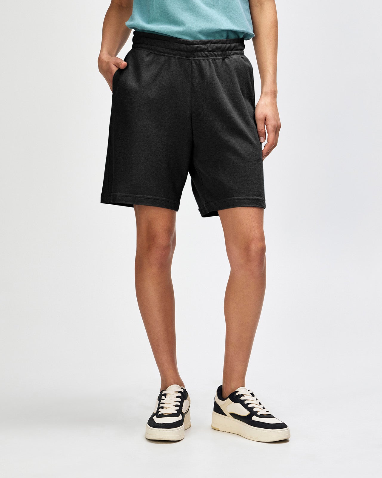 Model wearing a Pique Unisex Gym Shorts (front pose) -black