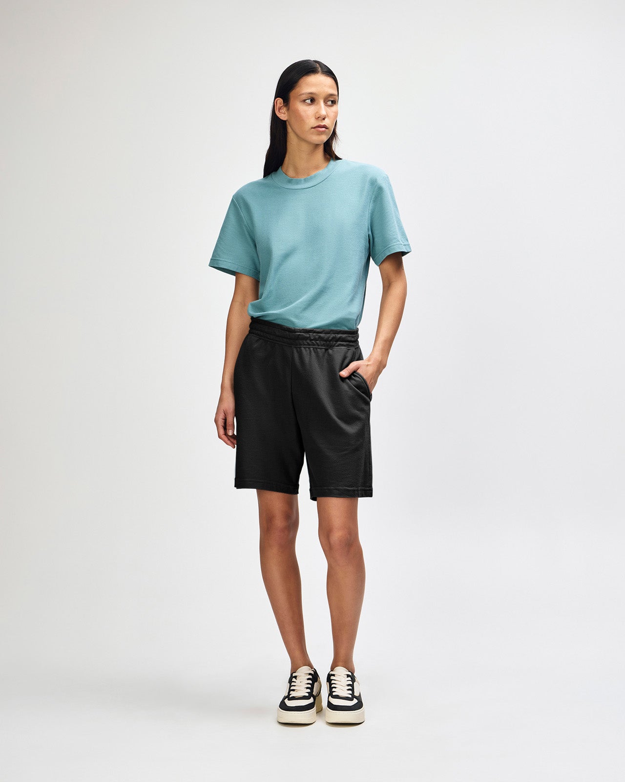 Model wearing a Pique Unisex Gym Shorts (front pose) -black