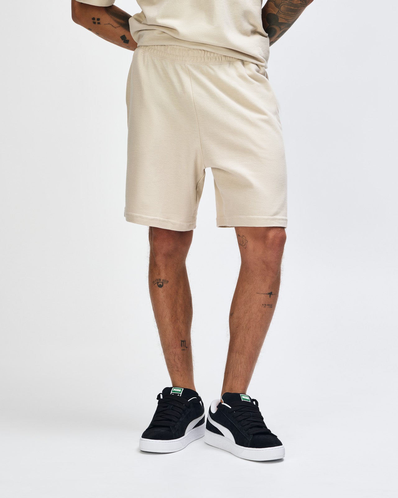 Model wearing a Pique Unisex Gym Shorts (front pose) -bone