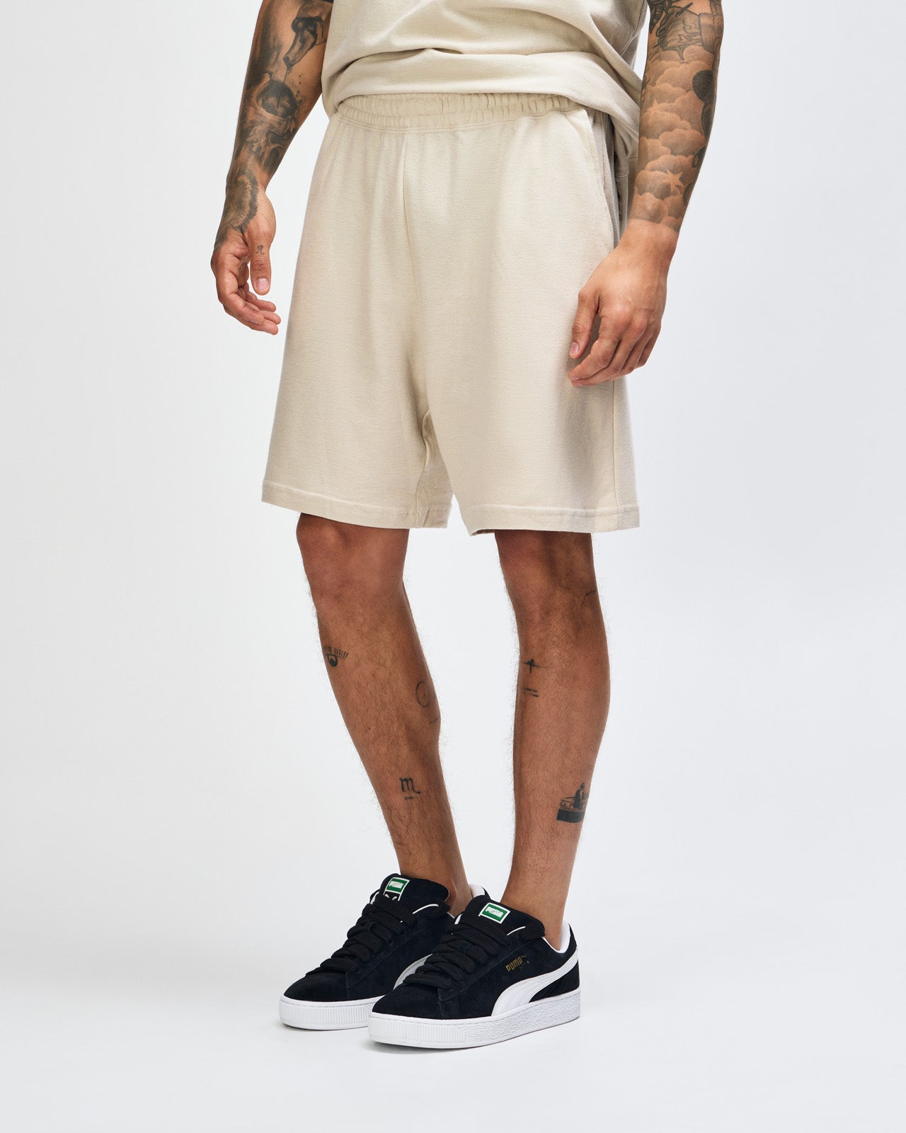 Model wearing a Pique Unisex Gym Shorts (front pose) -bone