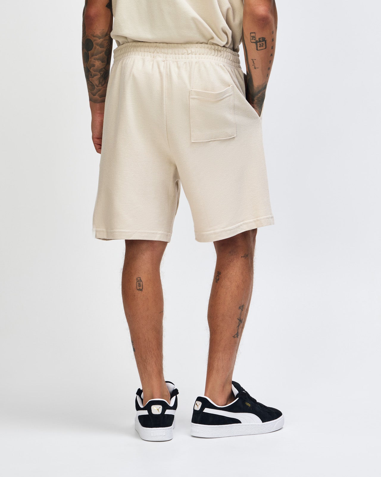 Model wearing a Pique Unisex Gym Shorts (front pose) -bone