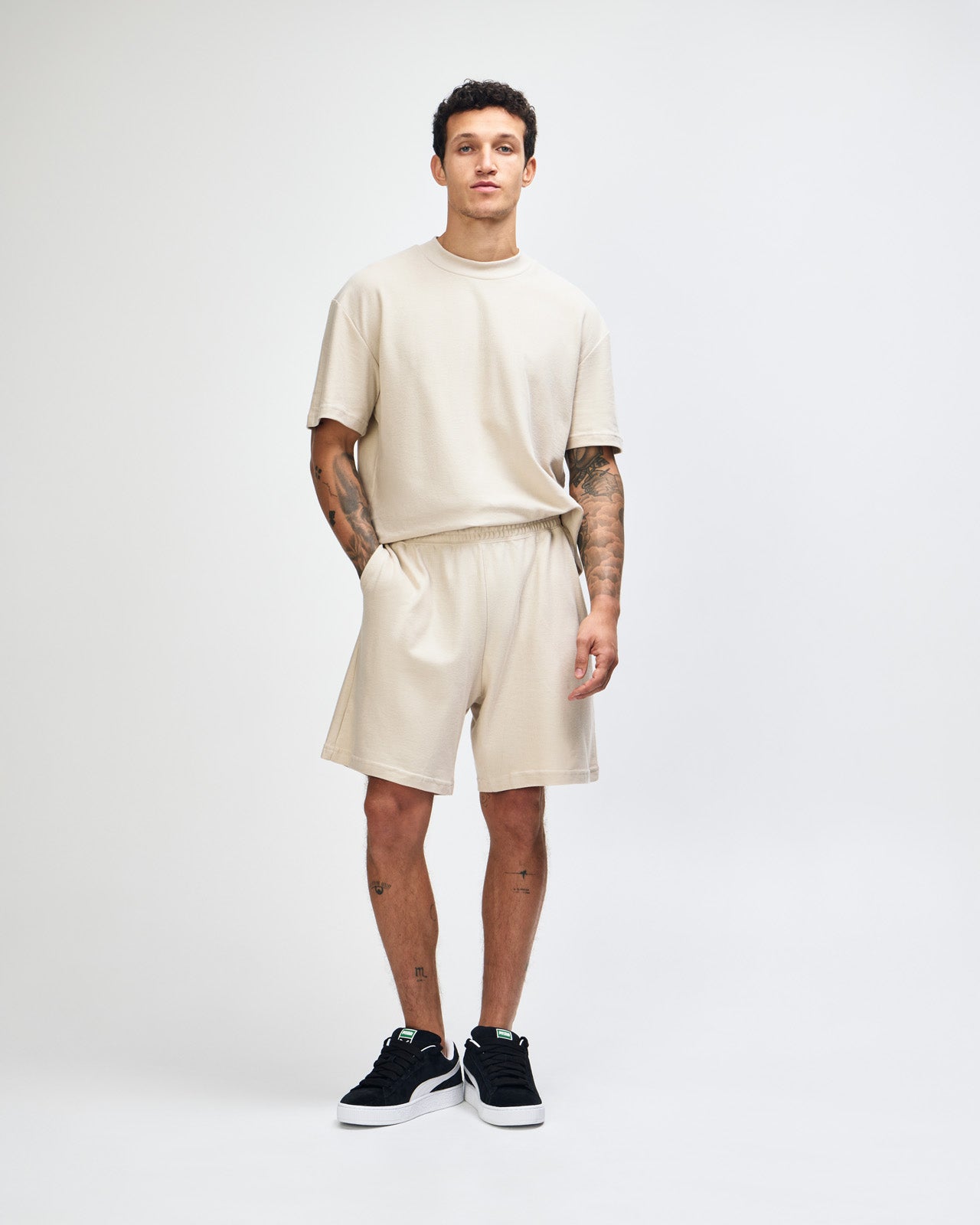 Model wearing a Pique Unisex Gym Shorts (front pose) -bone