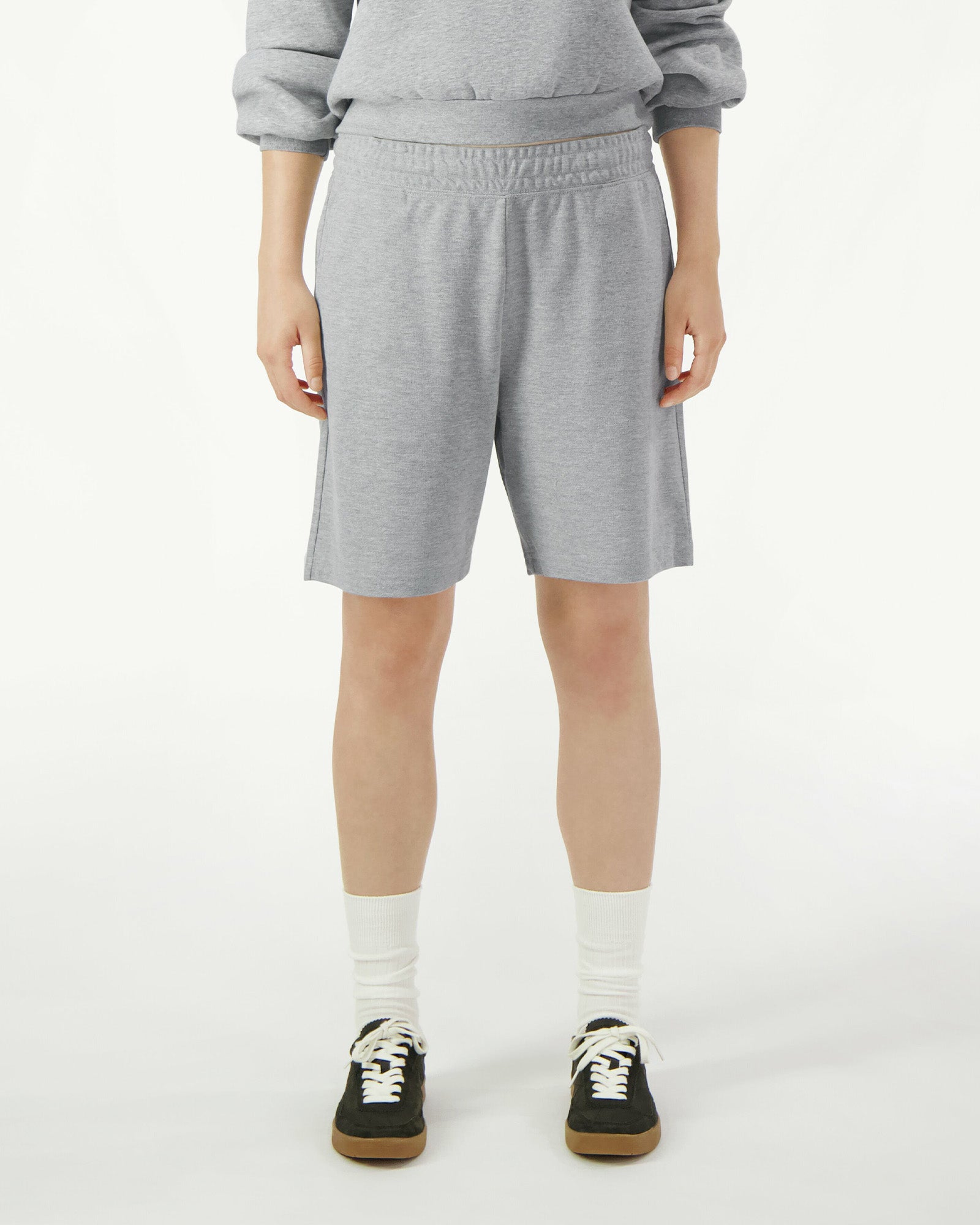 Model wearing a Pique Unisex Gym Shorts (front pose) -heather grey