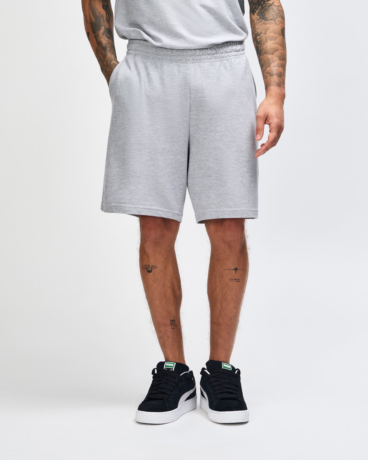 Model wearing a Pique Unisex Gym Shorts (front pose) -heather grey