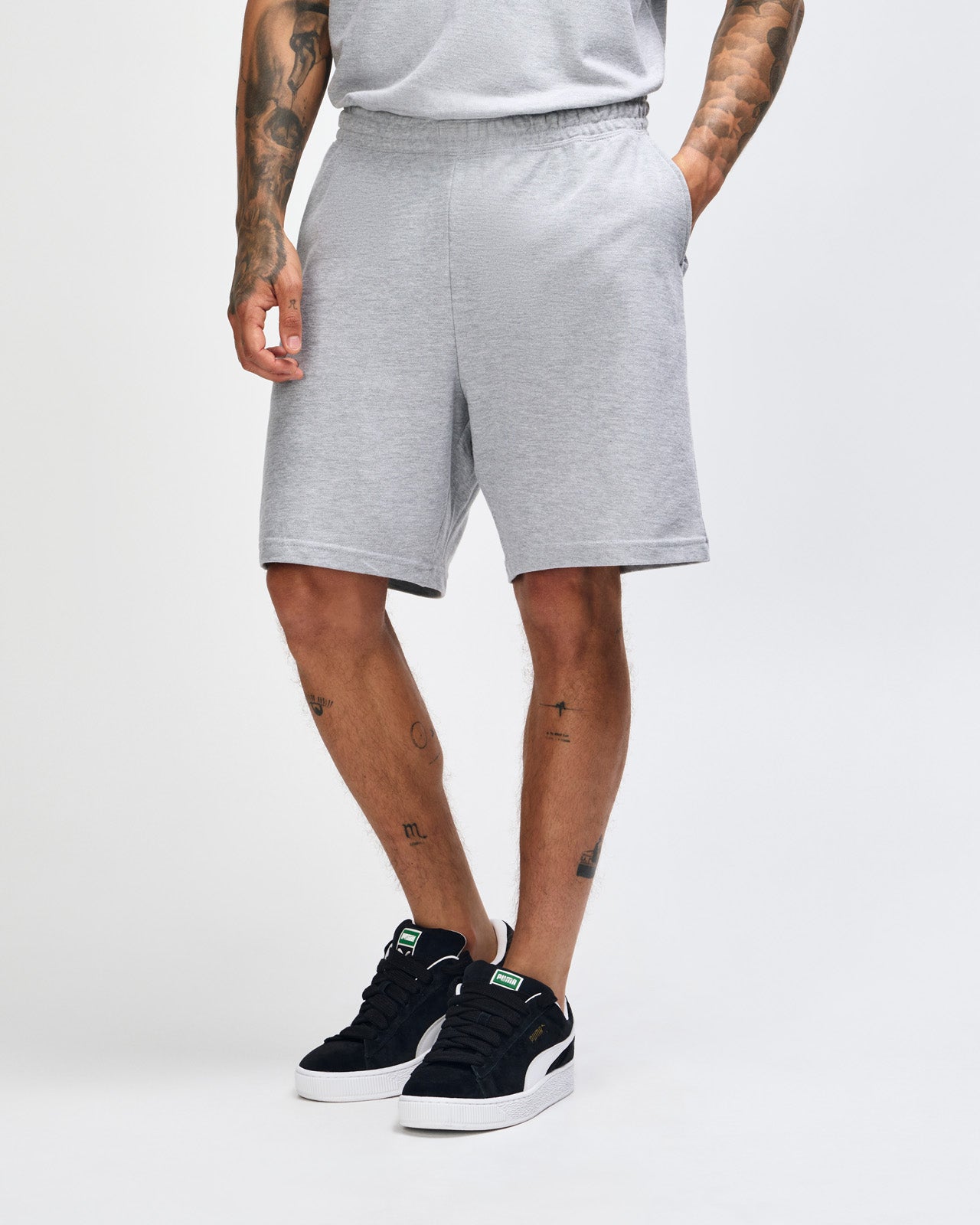 Model wearing a Pique Unisex Gym Shorts (front pose) -heather grey