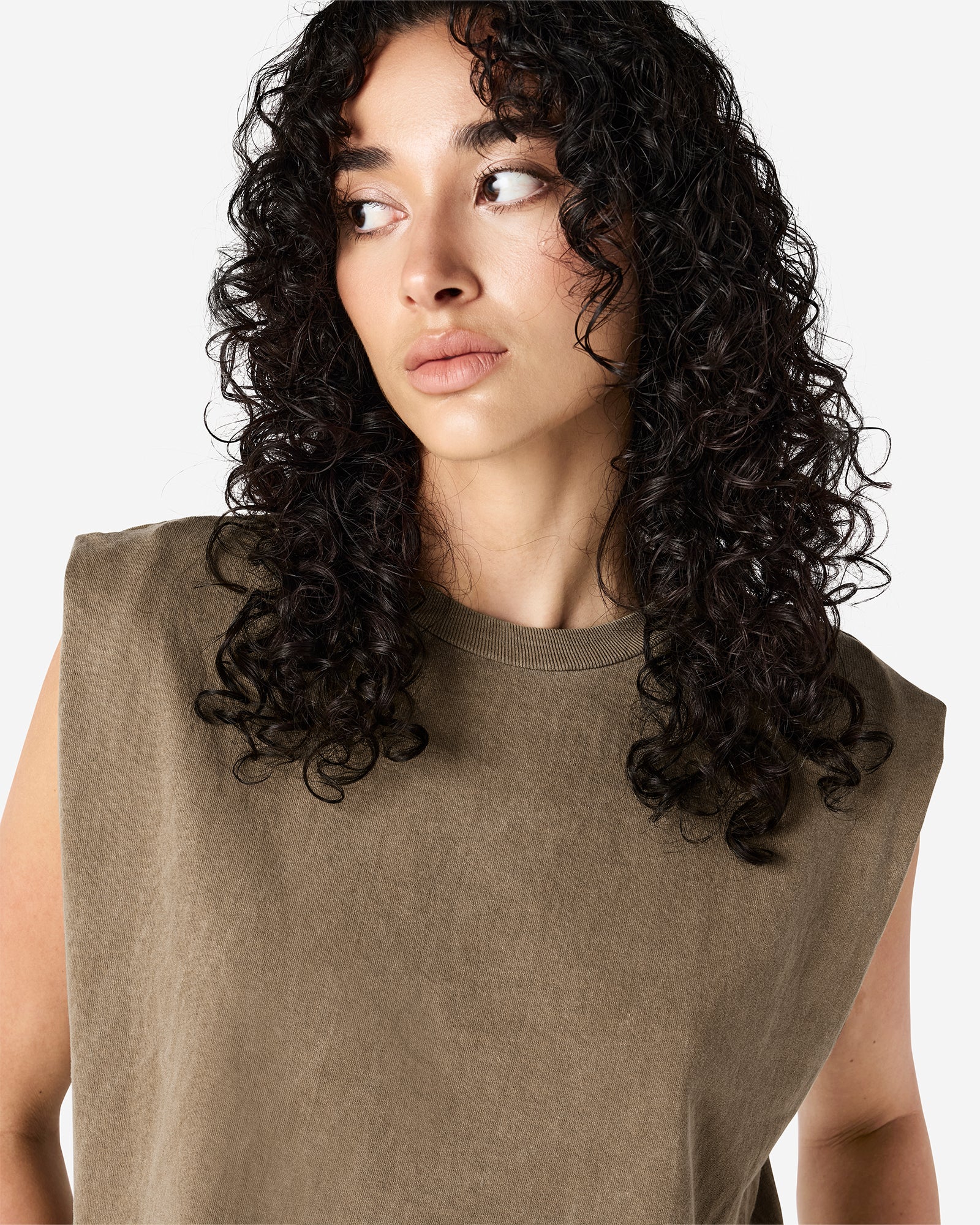 Model wearing a faded brown Garment Dyed Women's Muscle Tee, sleeveless, paired with light blue jeans, standing against a plain white background (front pose) -brown