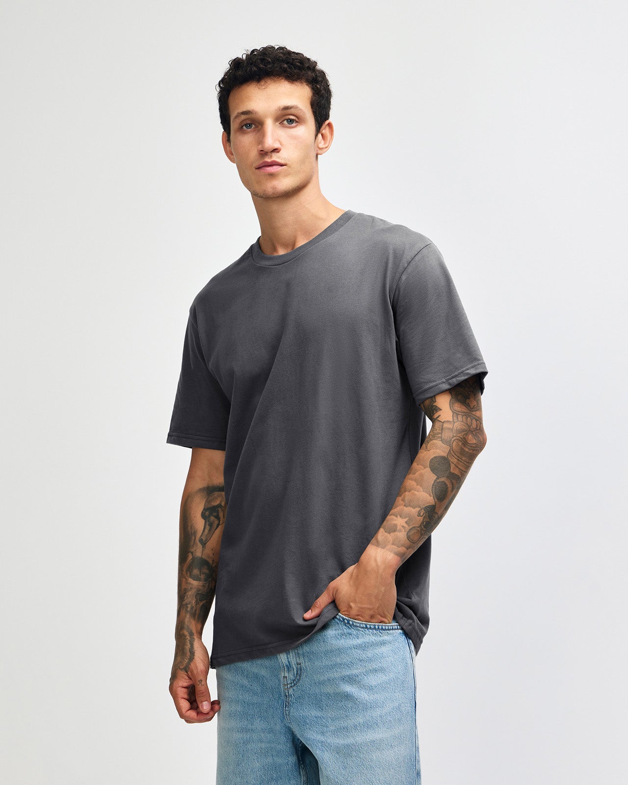 Male model wearing sueded white colour  Unisex Short Sleeve Crew Neck Tee (front pose) -asphalt