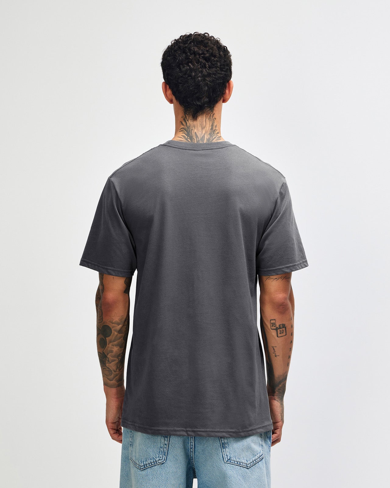 Male model wearing sueded white colour  Unisex Short Sleeve Crew Neck Tee (back pose) -asphalt