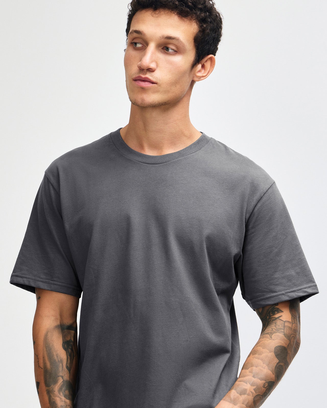 Male model wearing sueded white colour  Unisex Short Sleeve Crew Neck Tee (front pose) -asphalt