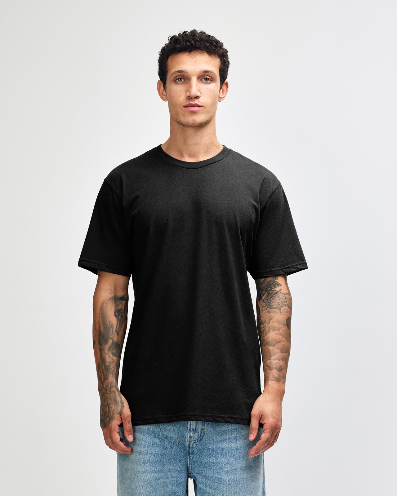 Male model wearing sueded white colour  Unisex Short Sleeve Crew Neck Tee (front pose) -black