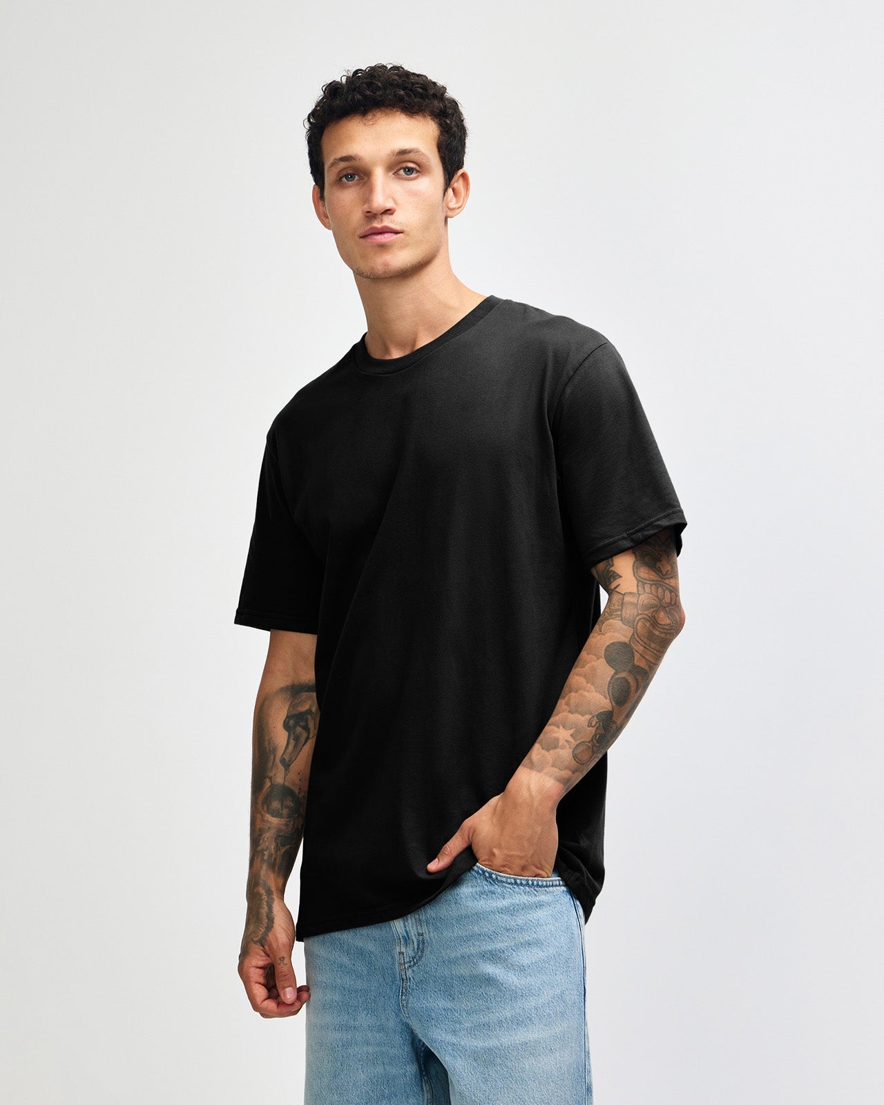 Male model wearing sueded white colour  Unisex Short Sleeve Crew Neck Tee (front pose) -black