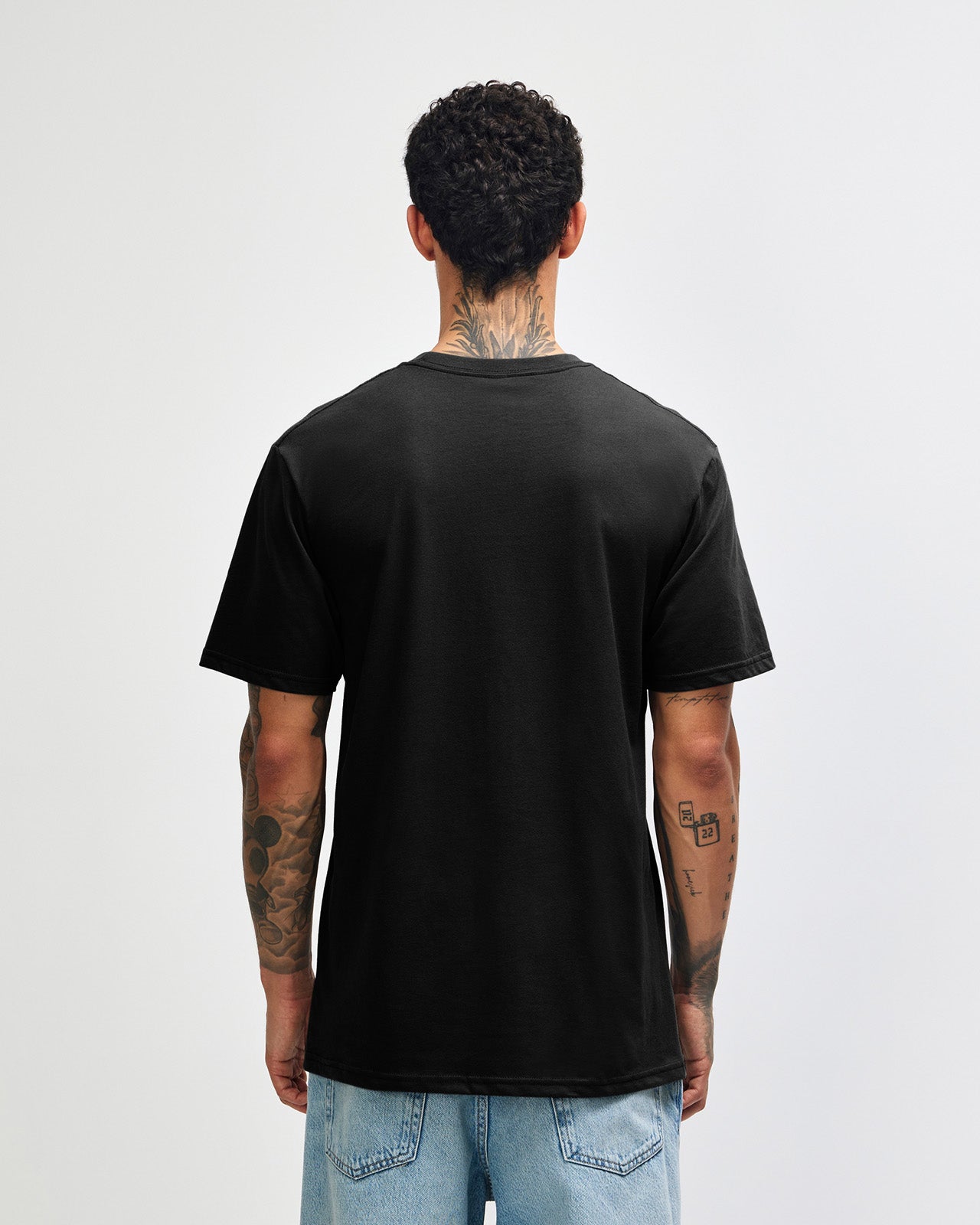 Male model wearing sueded white colour  Unisex Short Sleeve Crew Neck Tee (back pose) -black