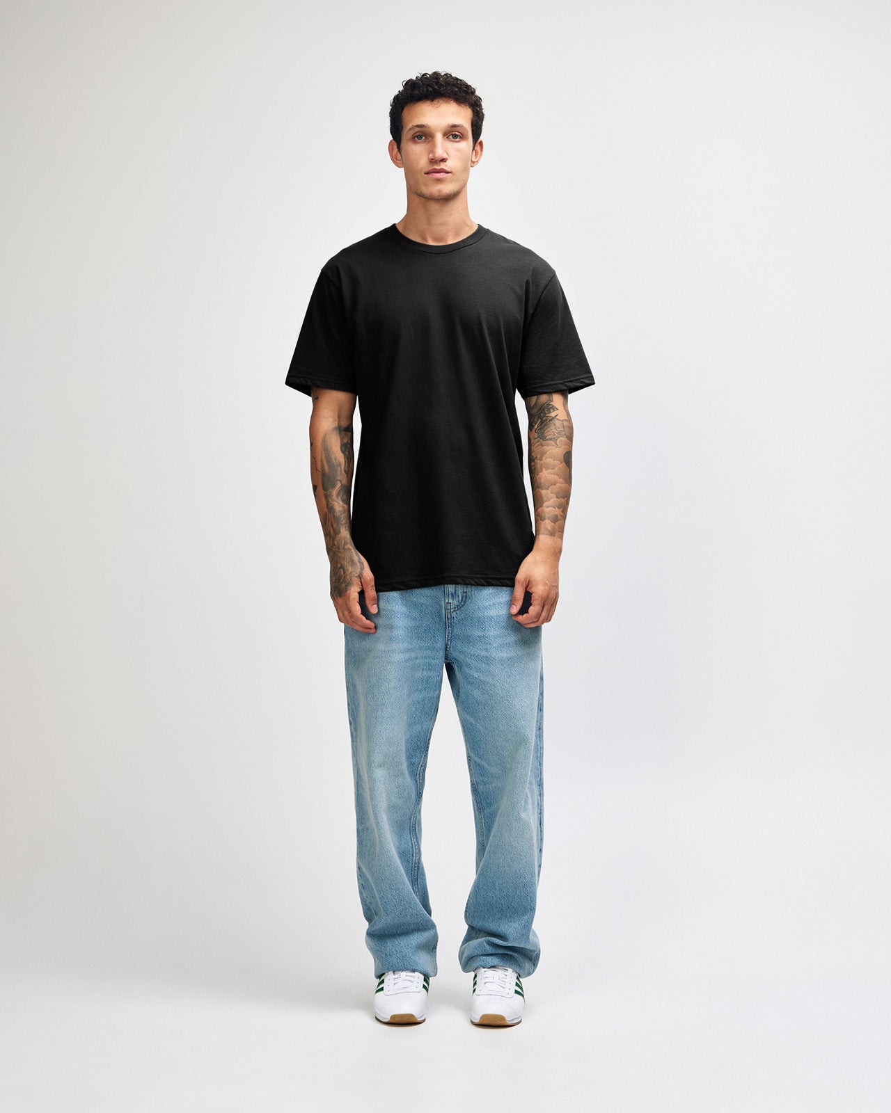 Male model wearing sueded white colour  Unisex Short Sleeve Crew Neck Tee (front pose) -black