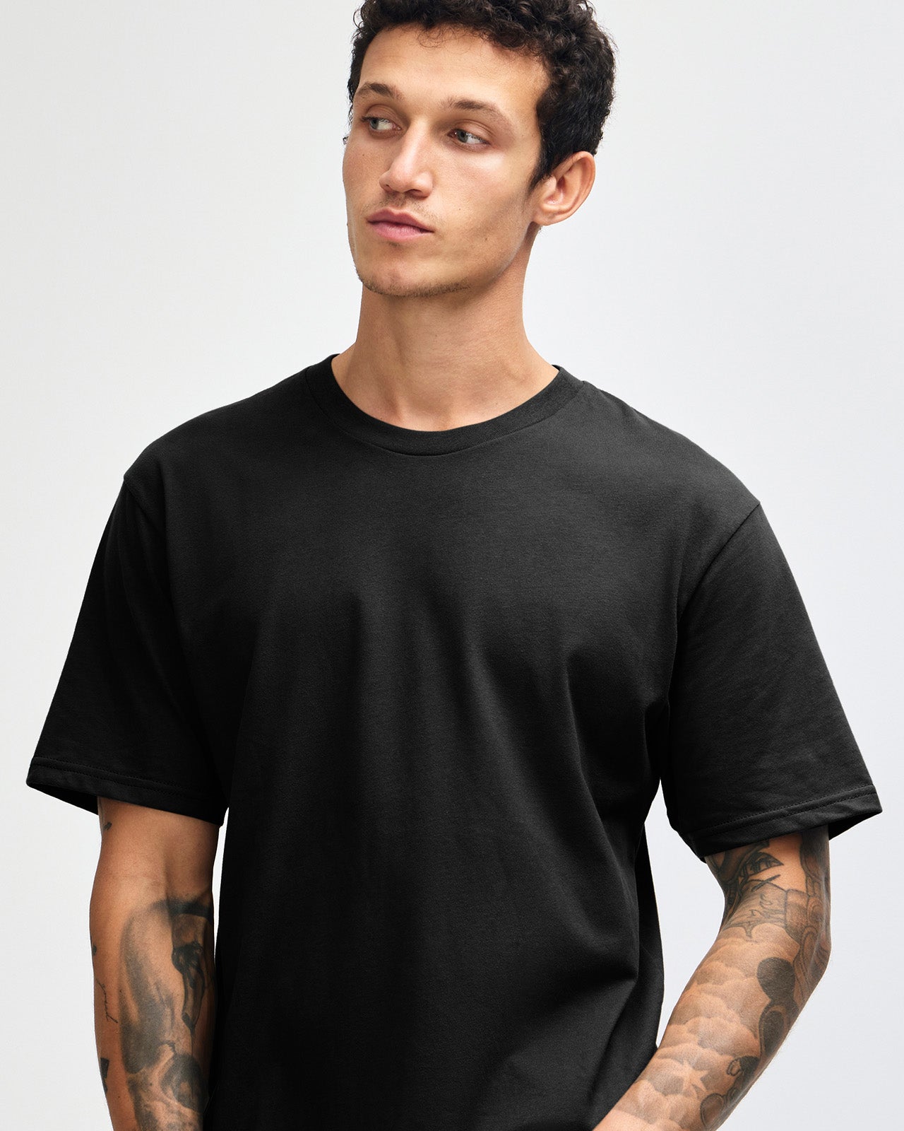 Male model wearing sueded white colour  Unisex Short Sleeve Crew Neck Tee (front pose) -black