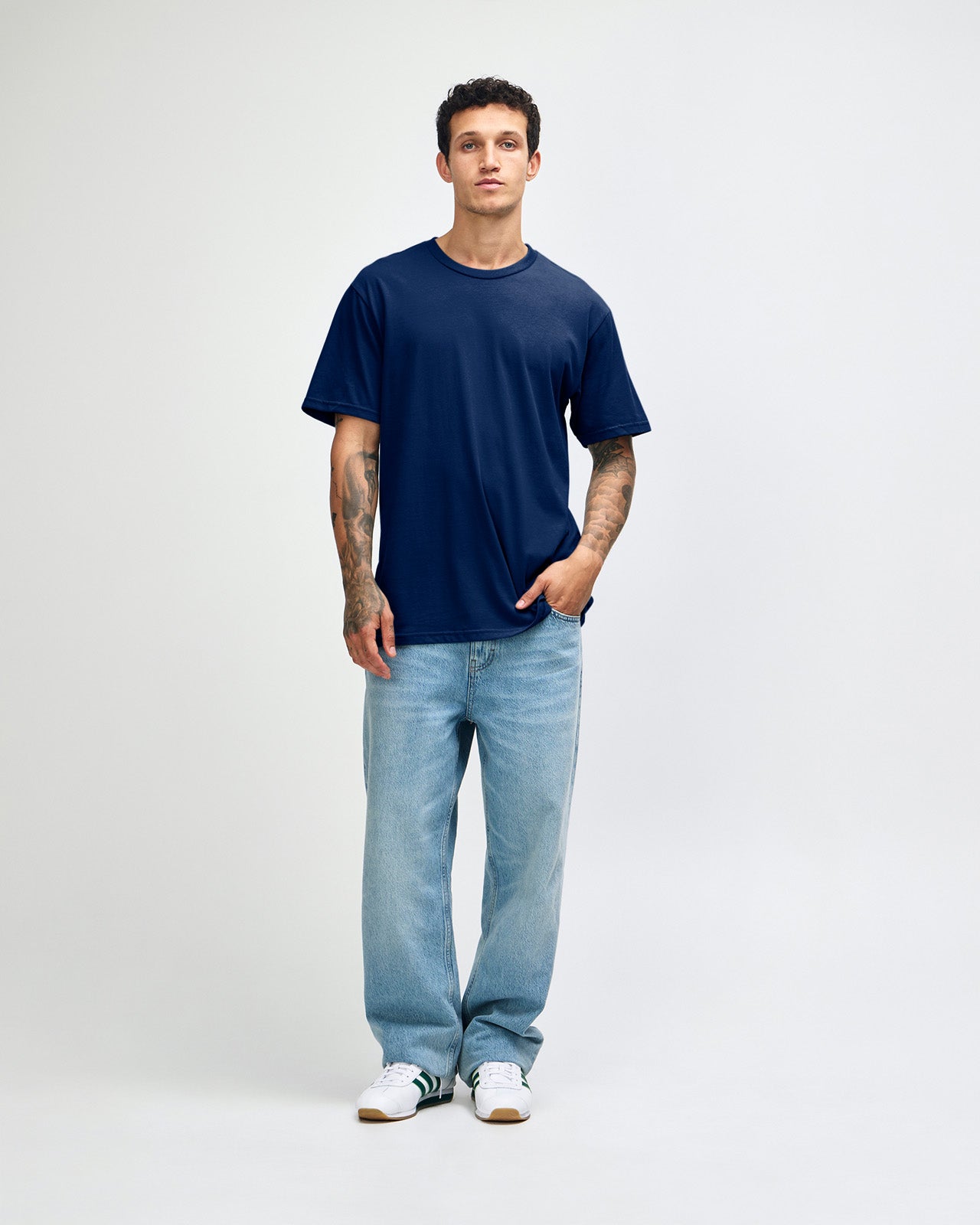 Male model wearing sueded white colour  Unisex Short Sleeve Crew Neck Tee (front pose) -navy