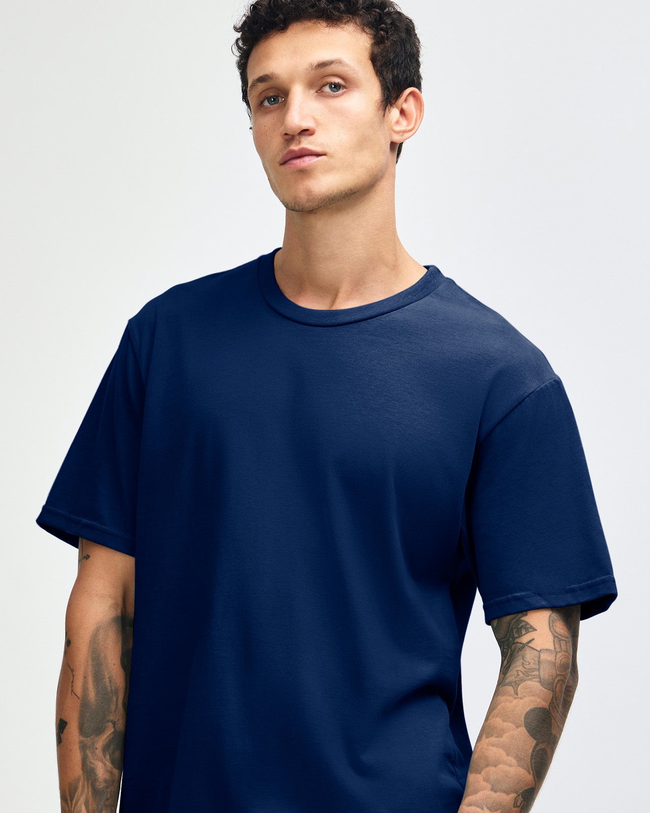 Male model wearing sueded white colour  Unisex Short Sleeve Crew Neck Tee (front pose) -navy
