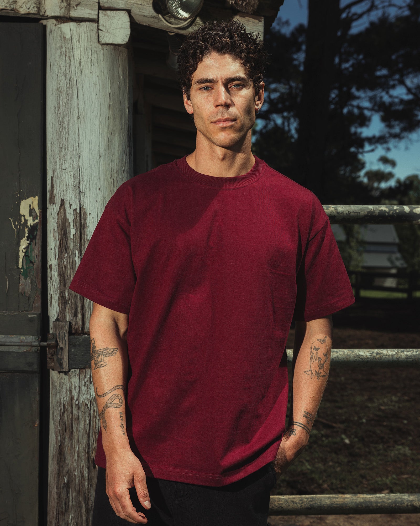 Male model wearing an American Apparel 9001 Unisex Oversized Fit Super Heavyweight T-shirt - burgundy