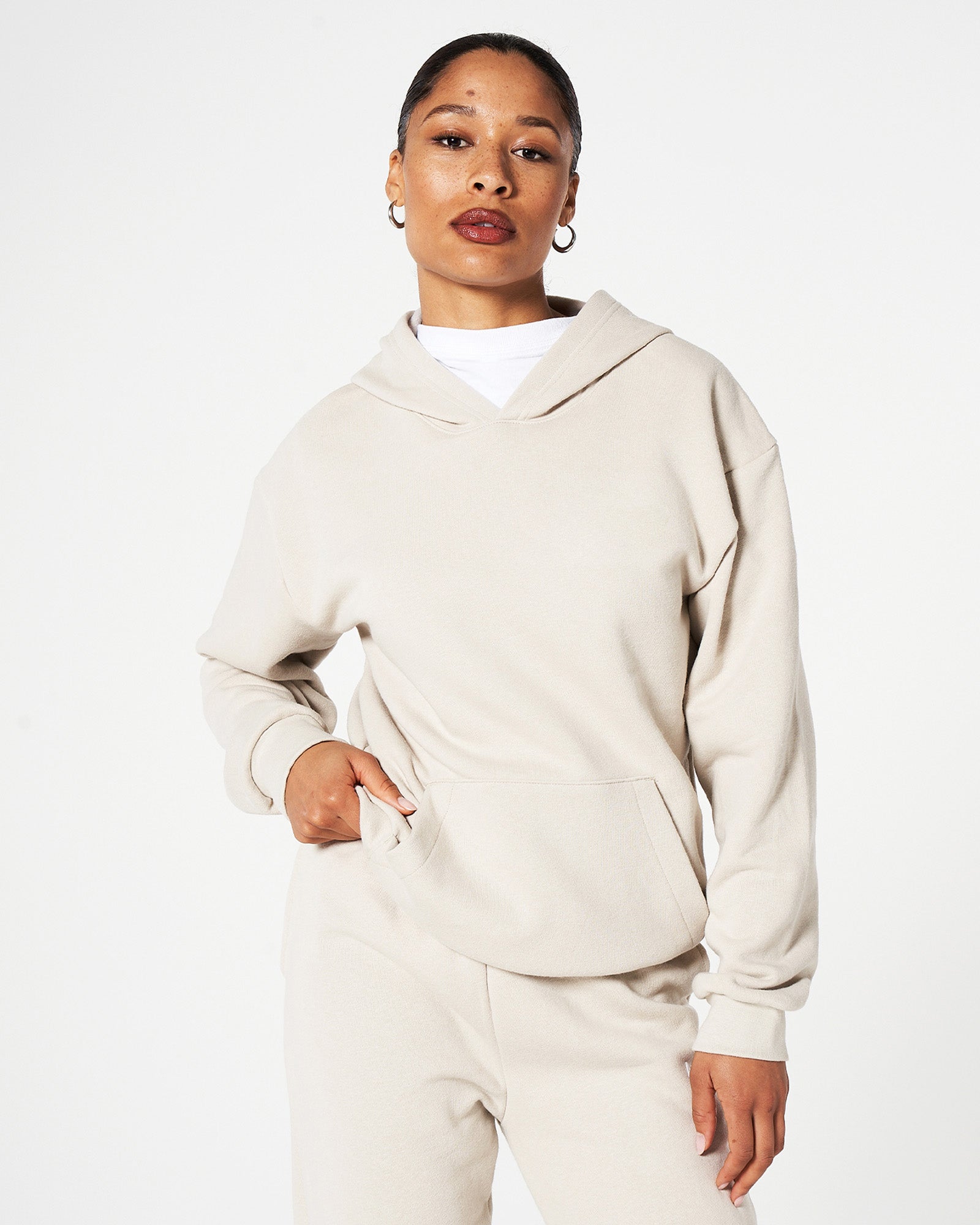 Female model wearing an American Apparel bone hoodie and sweatpants tracksuit set