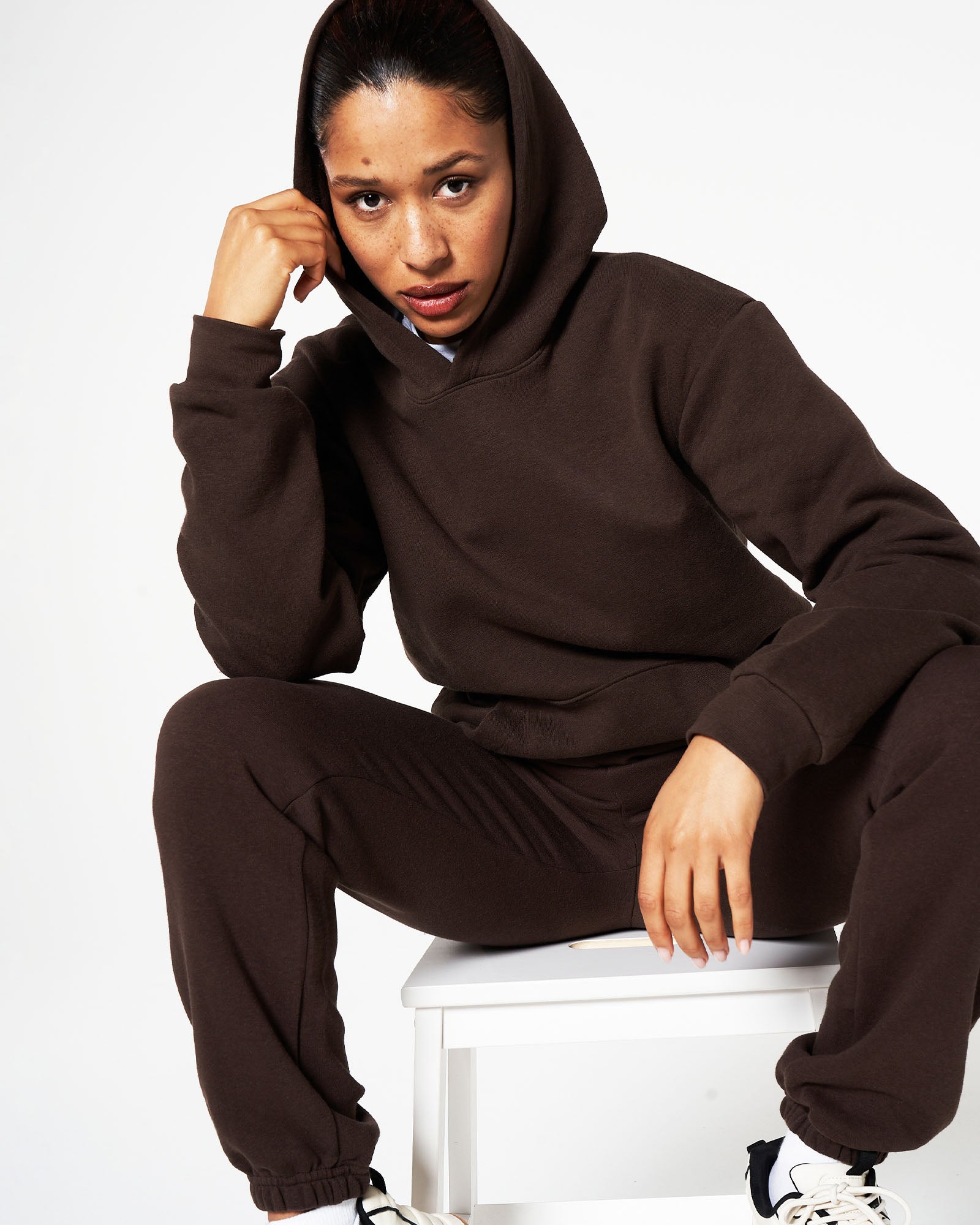 Female model posing while wearing American Apparel Brown Hoodie & Sweatpants Tracksuit Set (front pose) -brown