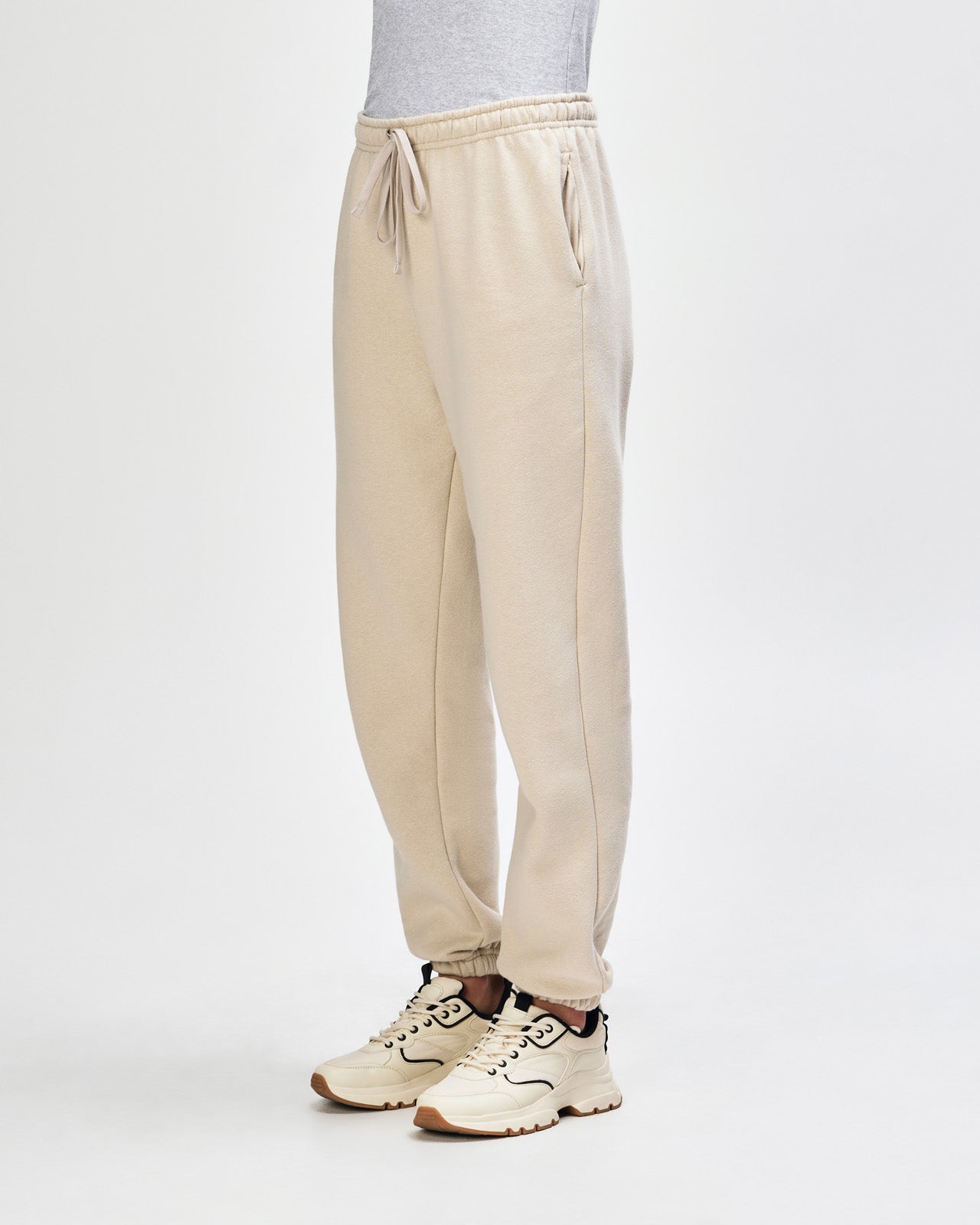 Female model wearing American Apparel Sweatpants (front pose) -bone