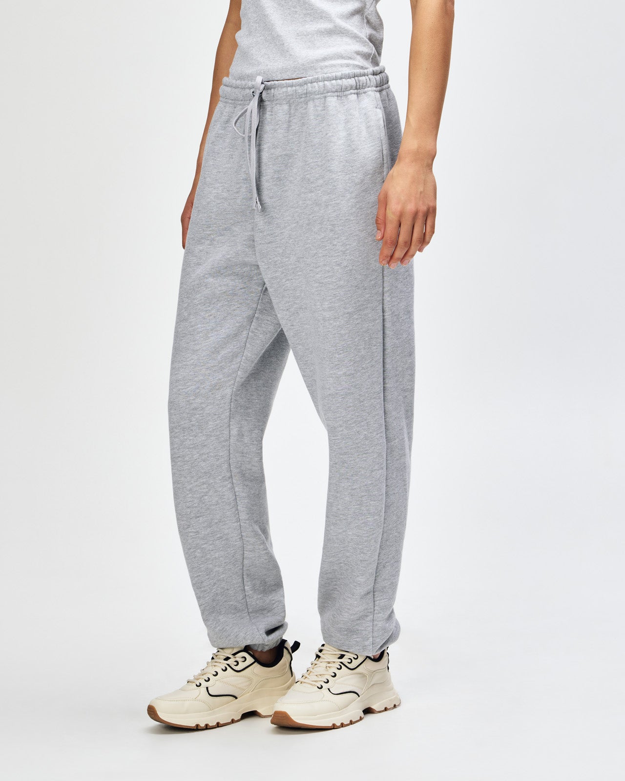 Female model wearing American Apparel Sweatpants (front pose) -heather grey