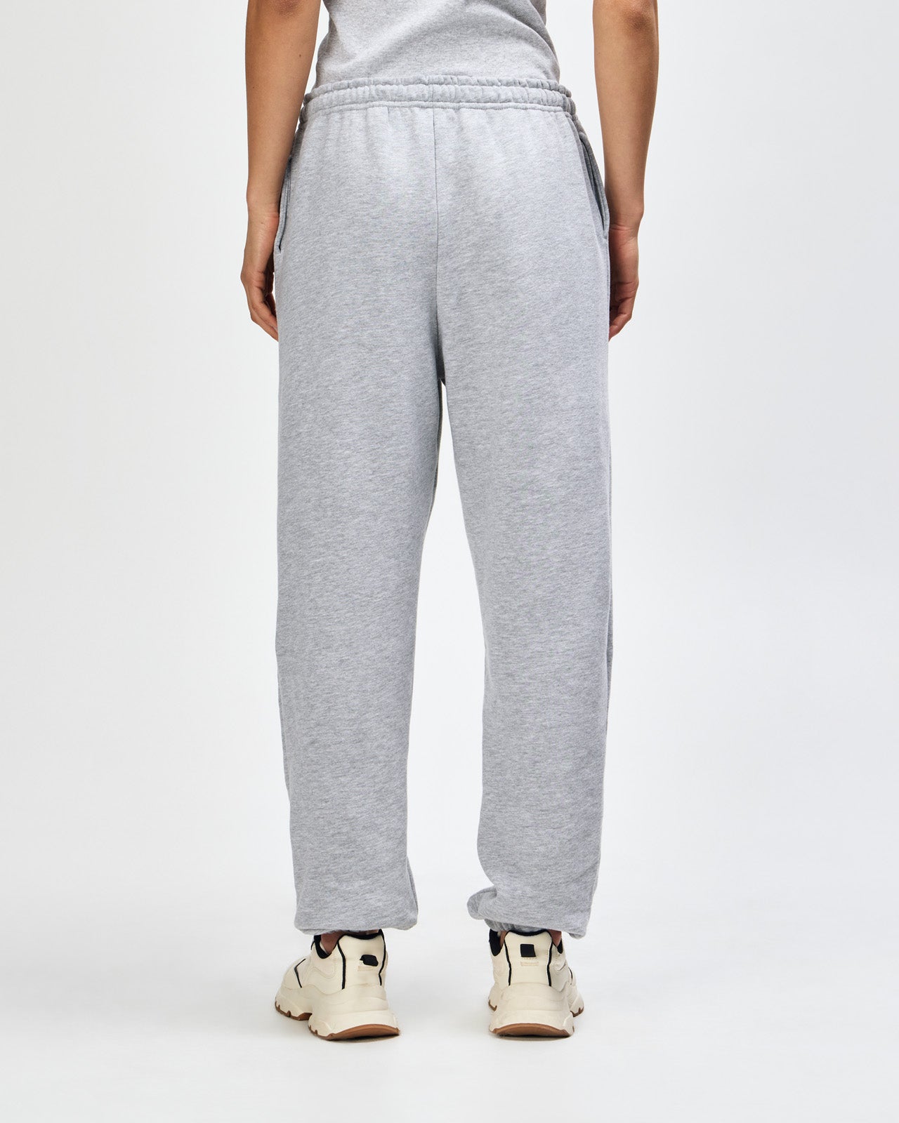 Female model wearing American Apparel Sweatpants (back pose) -heather grey