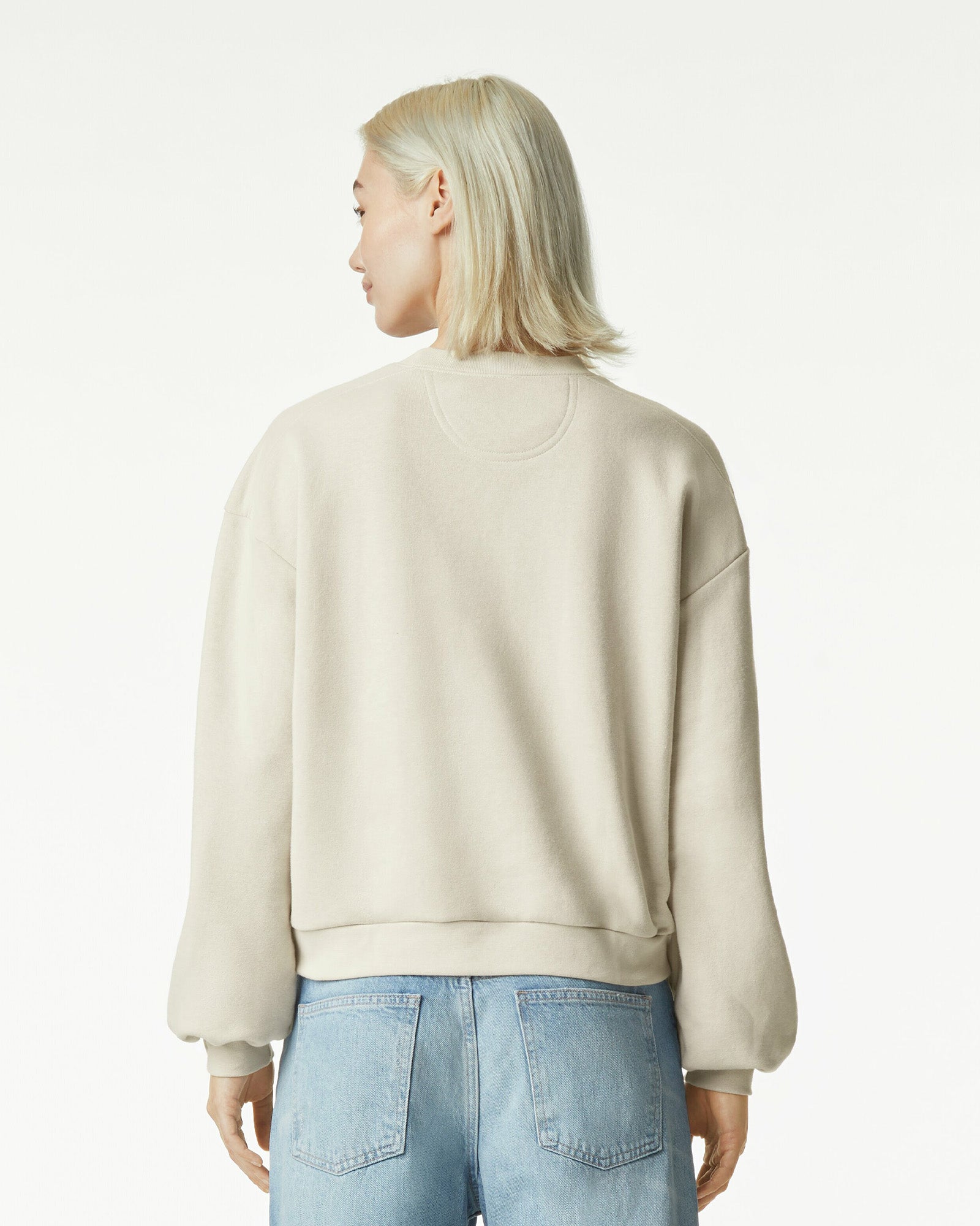 Model wearing a bone colour sweatshirt pairing with blue jeans (back pose) -bone