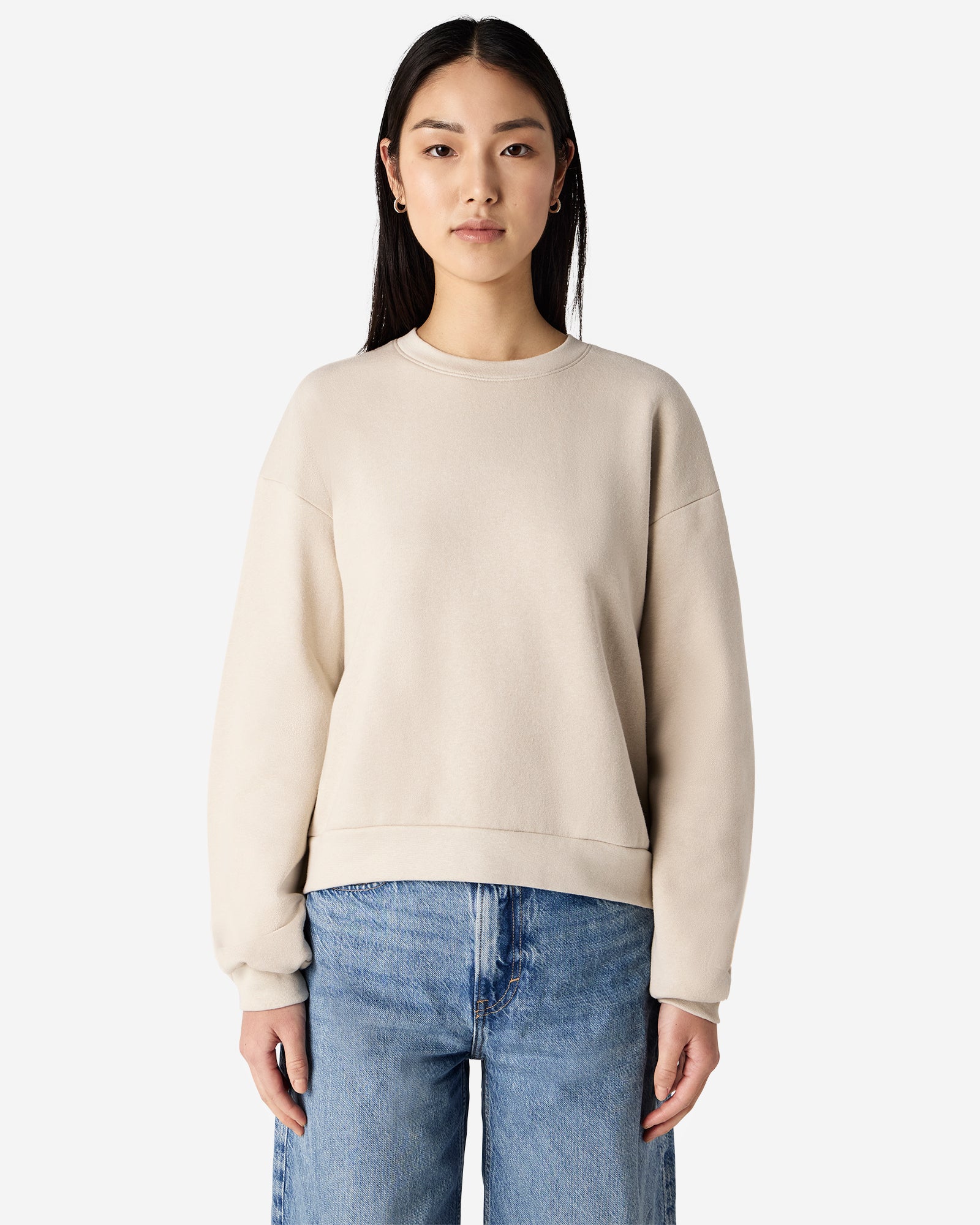Model wearing a bone colour sweatshirt pairing with blue jeans (front pose) - bone