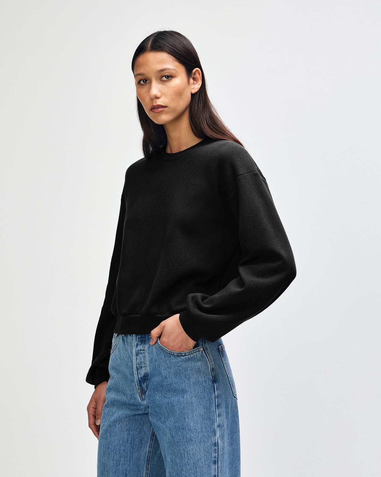 Model wearing a black colour sweatshirt pairing with blue jeans (front pose) -black
