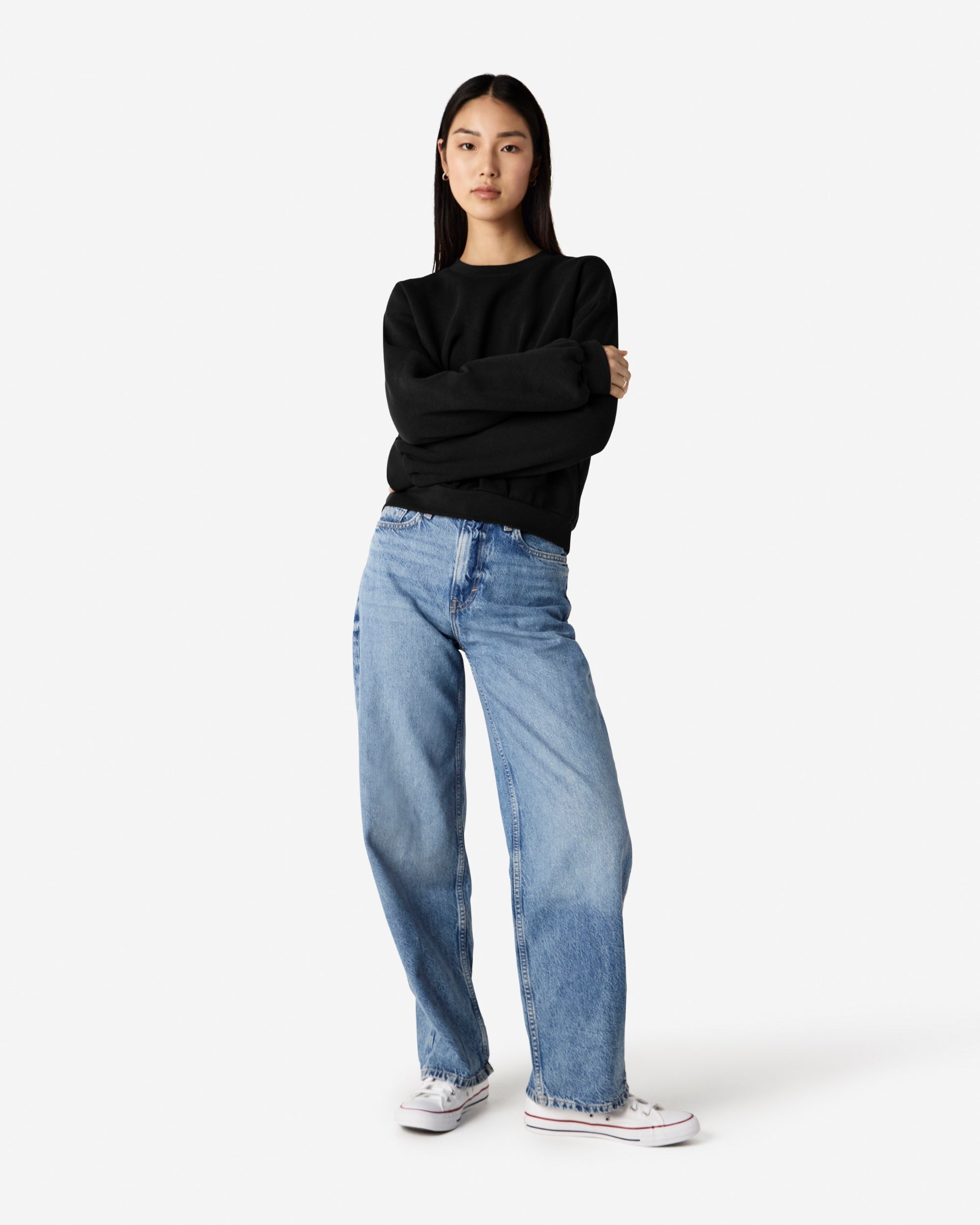 Model wearing a black colour sweatshirt pairing with blue jeans (front pose) -black
