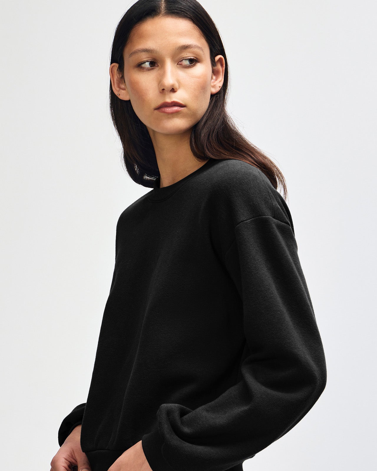Model wearing a black colour sweatshirt pairing with blue jeans (front pose) -black