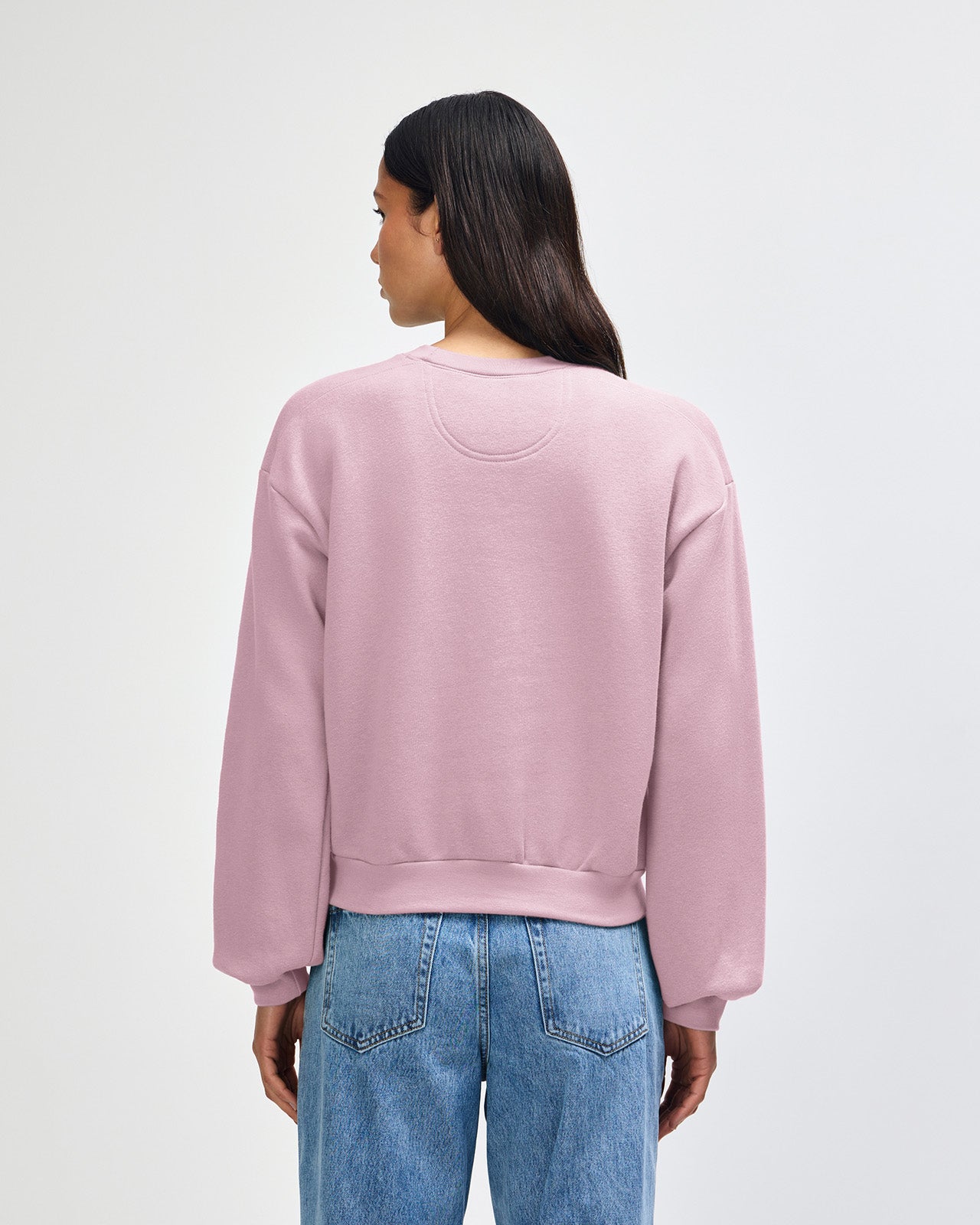 Model wearing a blush colour sweatshirt pairing with blue jeans (back pose) -blush