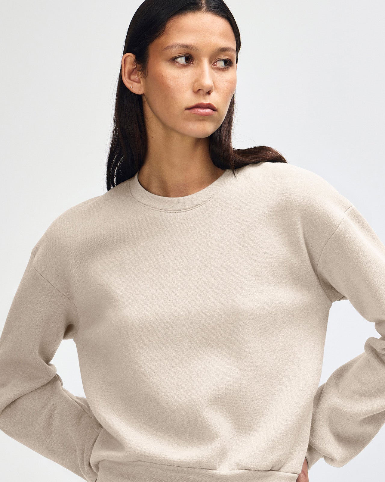Model wearing a bone colour sweatshirt pairing with blue jeans (front pose) - bone