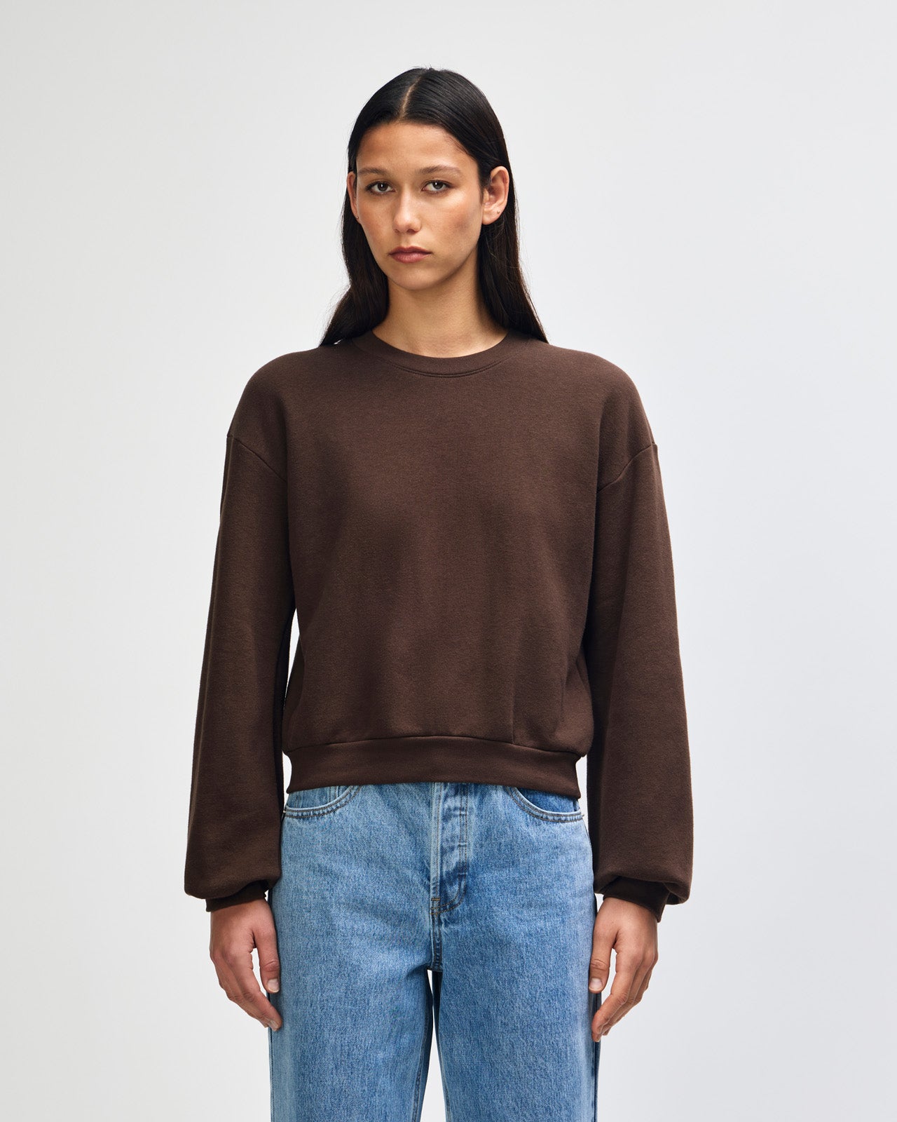 Model wearing a brown colour sweatshirt pairing with blue jeans (front pose) -brown