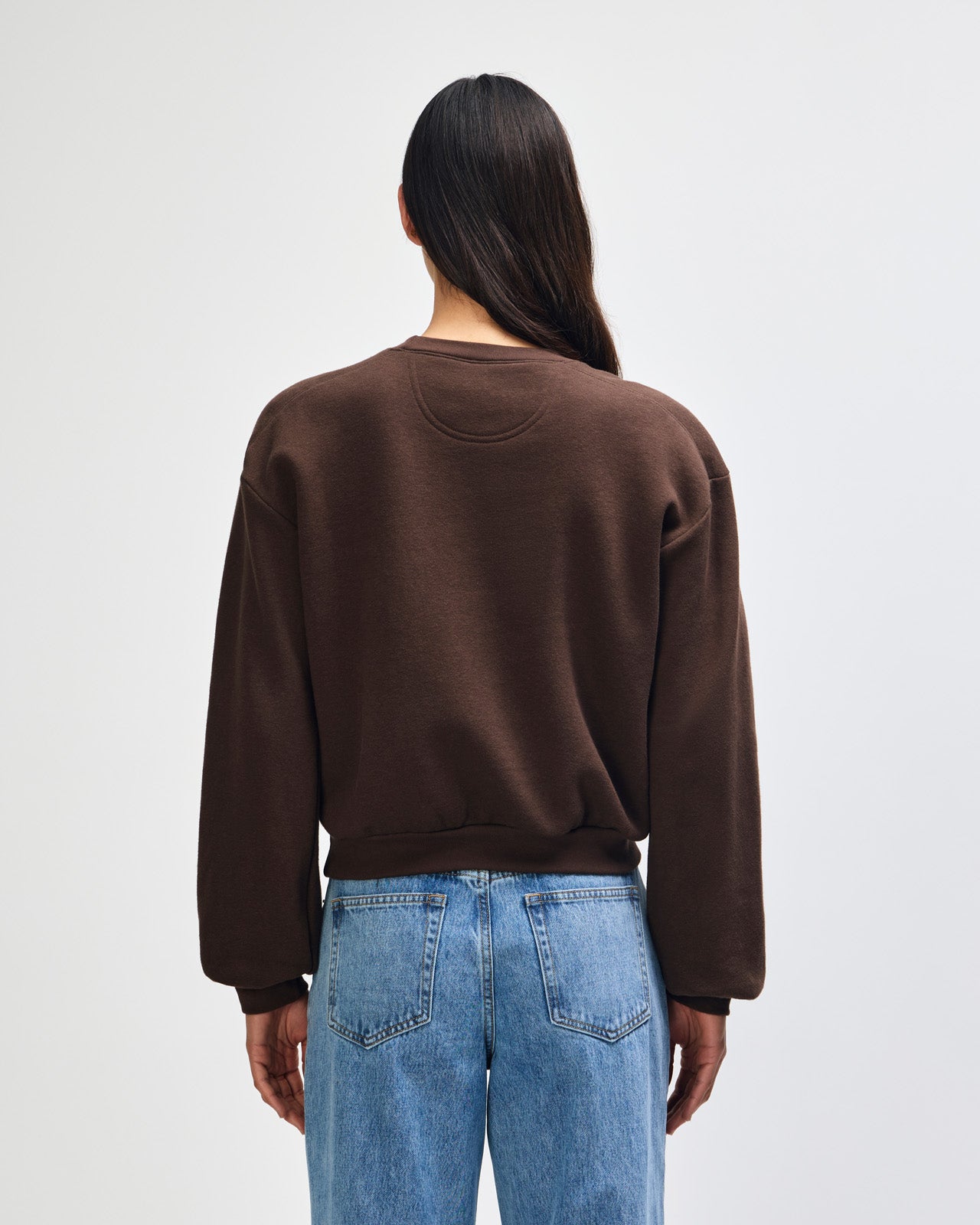Model wearing a brown colour sweatshirt pairing with blue jeans (back pose) -brown