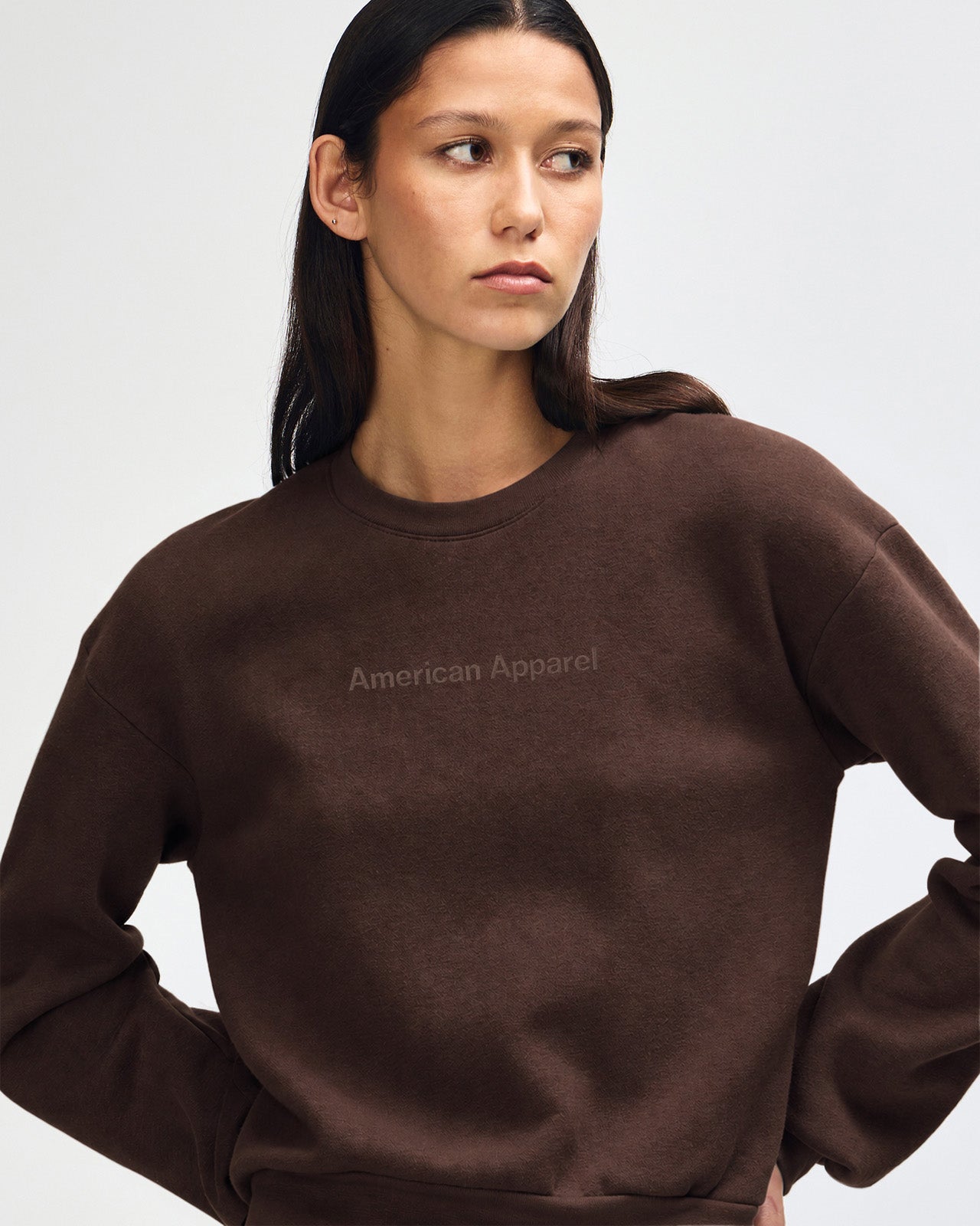 Person wearing a brown American Apparel sweatshirt on a plain background-brown