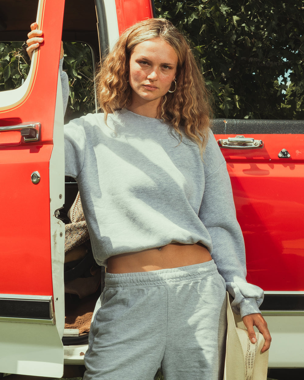 next image of Women's Crop Sweatshirt Tracksuit - Heather Grey : Model wearing a heather grey colour sweatshirt pairing with blue jeans (front pose) -heather grey