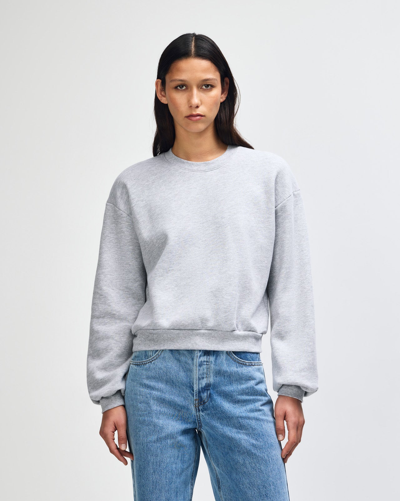 Model wearing a heather grey colour sweatshirt pairing with blue jeans (front pose) -heather grey