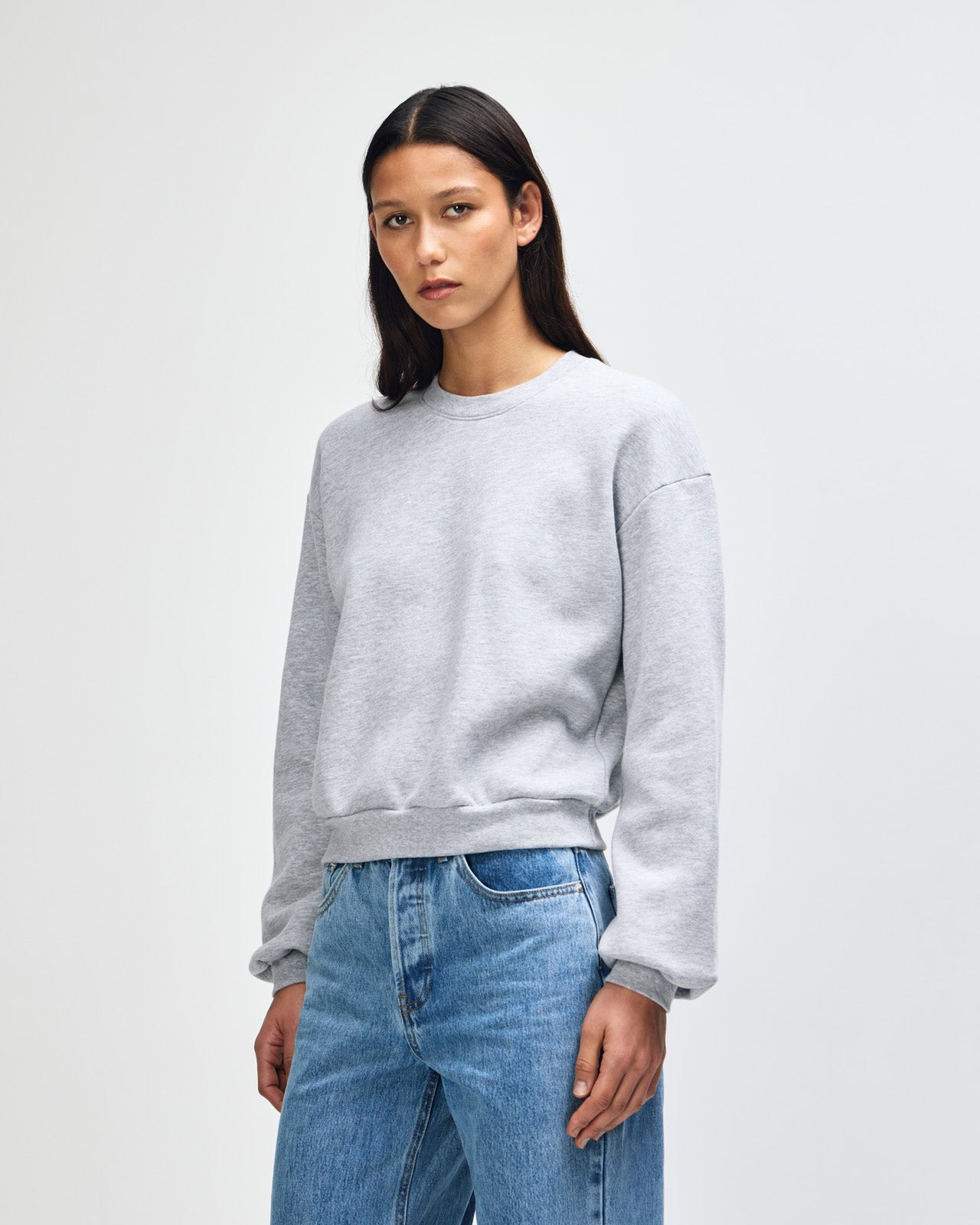 Model wearing a heather grey colour sweatshirt pairing with blue jeans (front pose) -heather grey